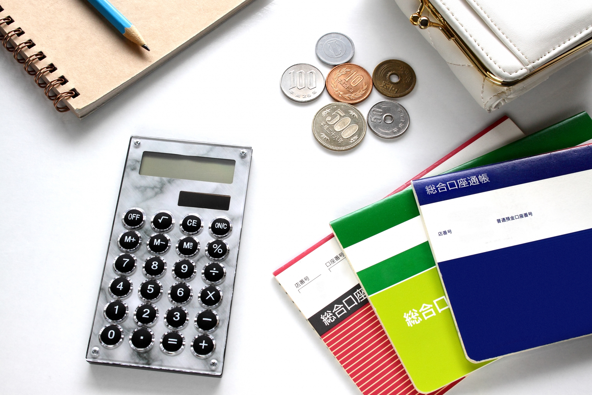 通帳と硬貨と電卓