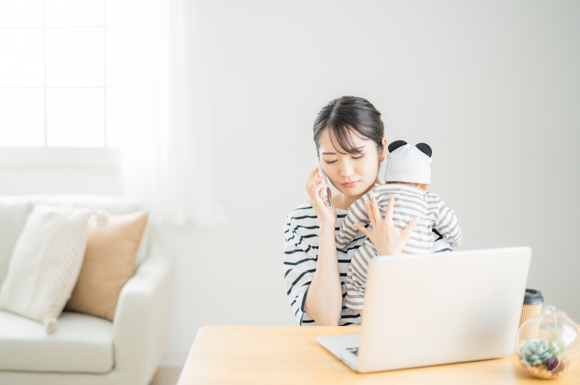 赤ちゃんを抱いて仕事する女性
