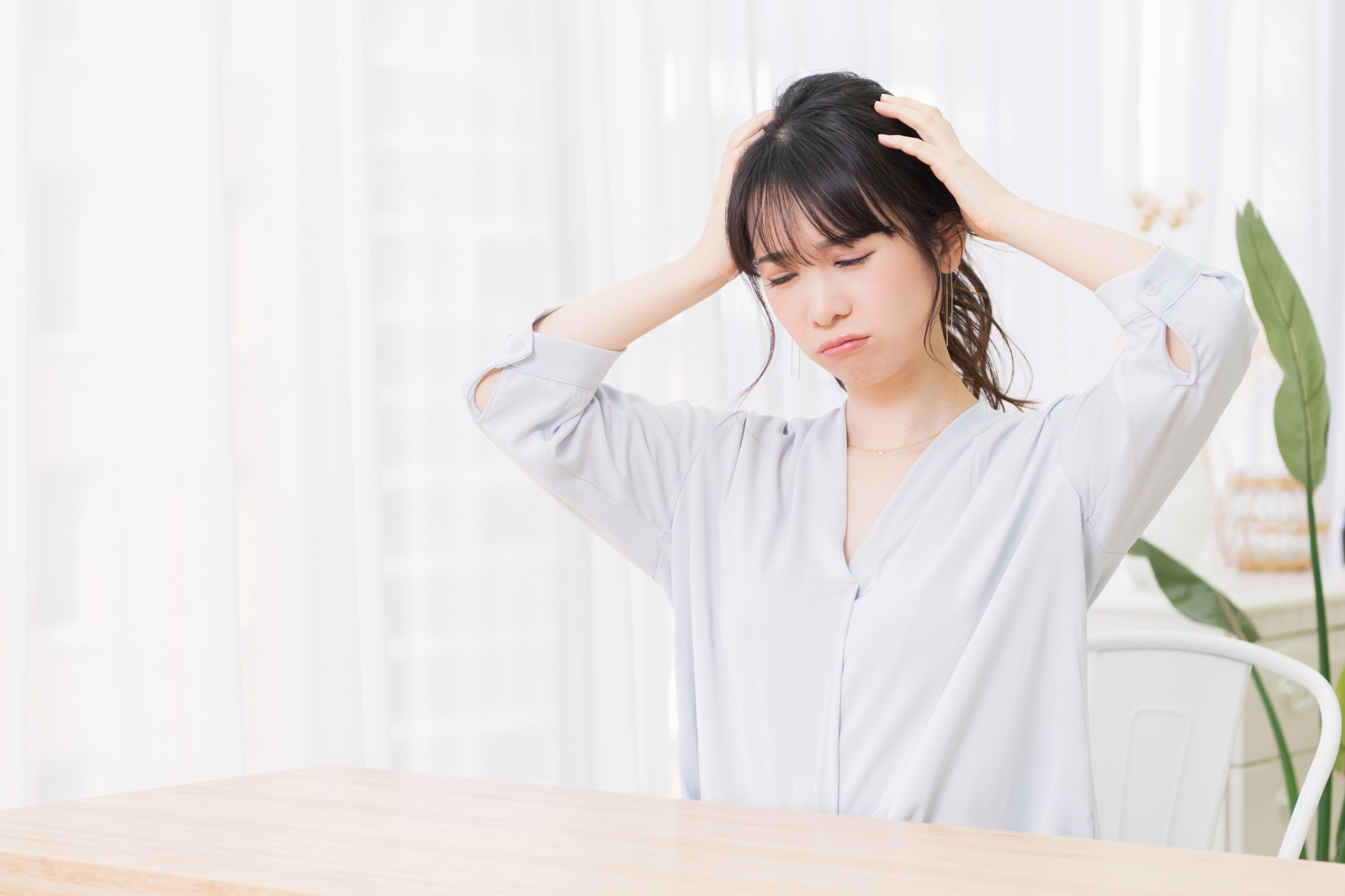 部屋で悩んでいる若い女性