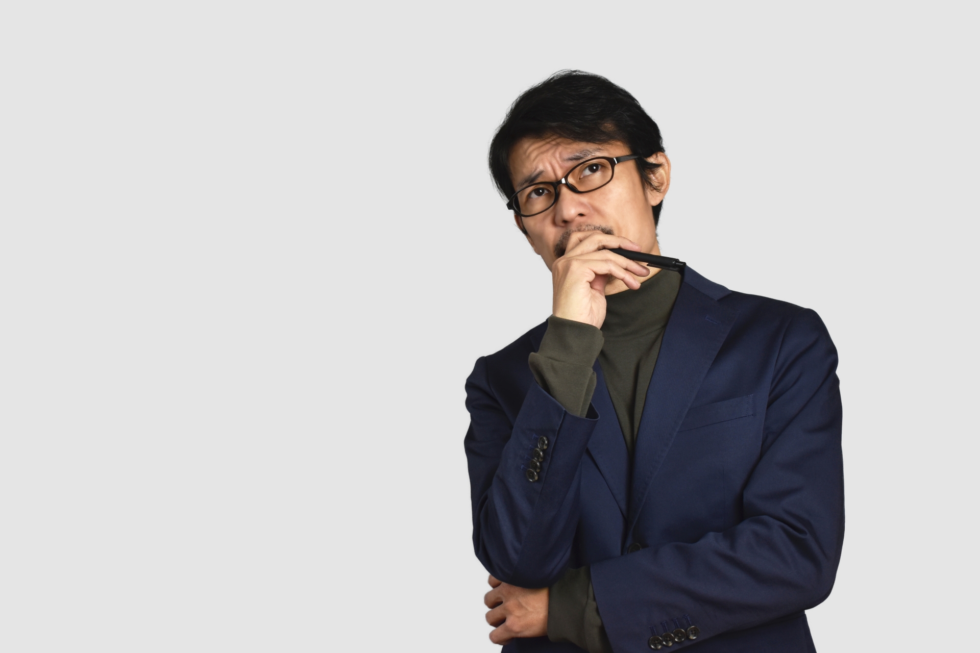 顎に手を当てて考えるビジネスマン