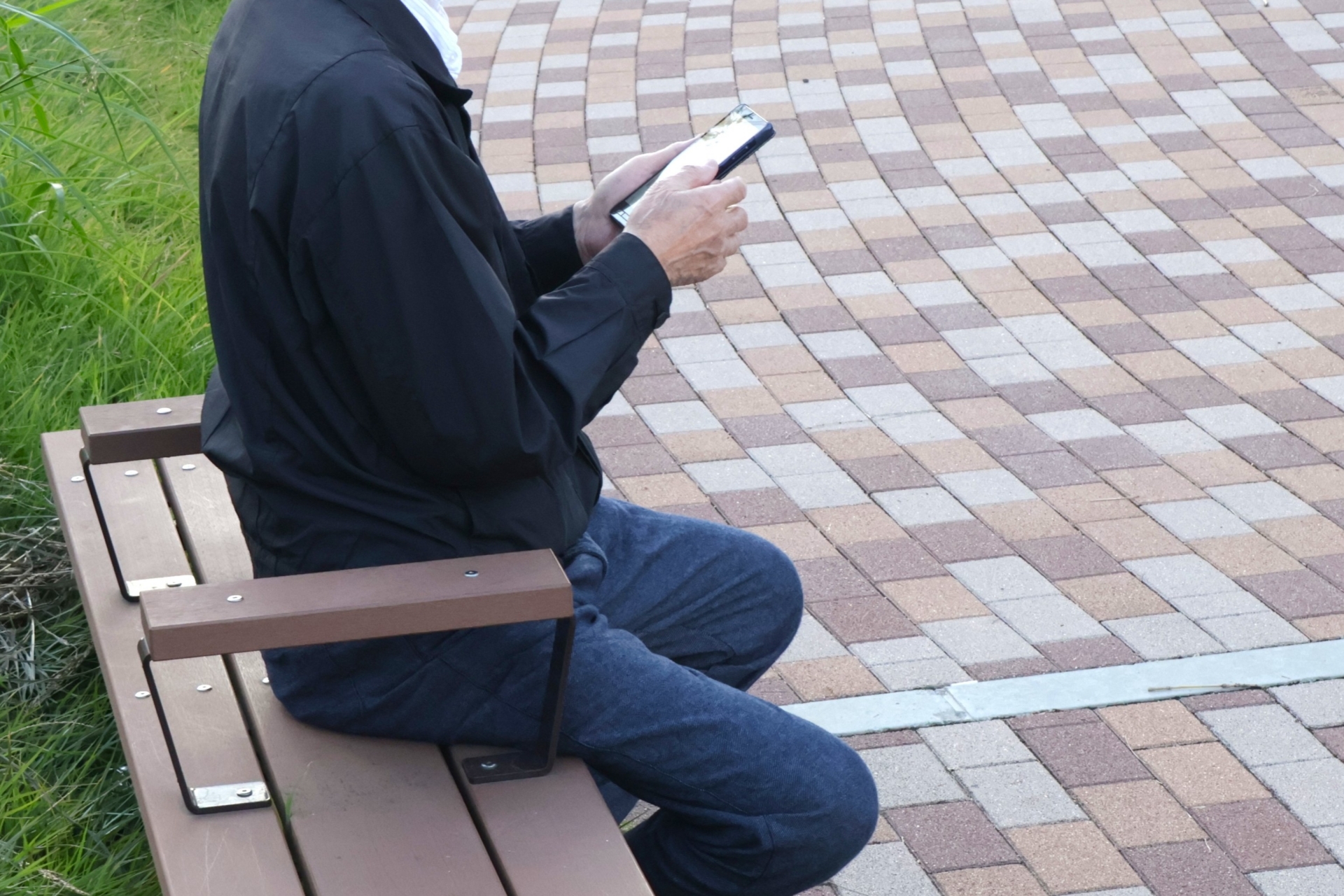 ベンチでスマホを見る人