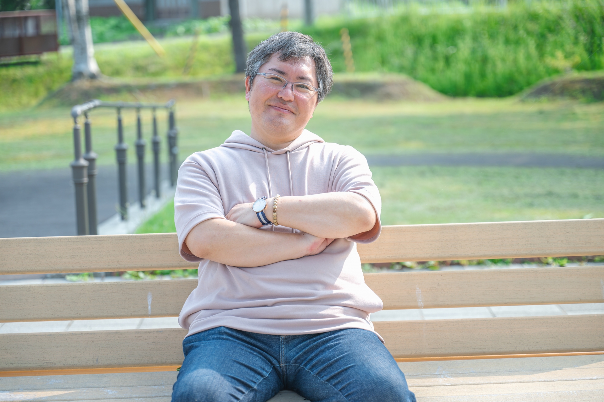 ベンチに座って腕を組む男性