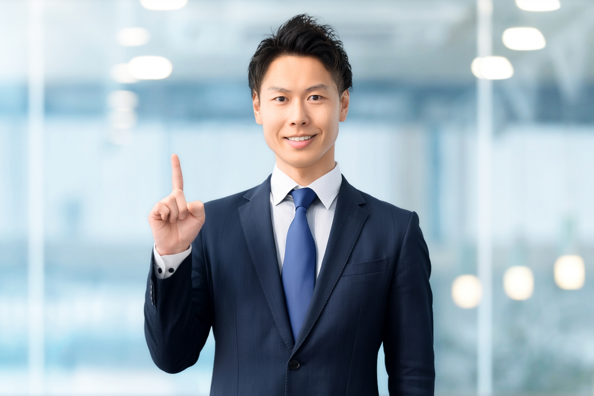 指を立てるスーツの男性