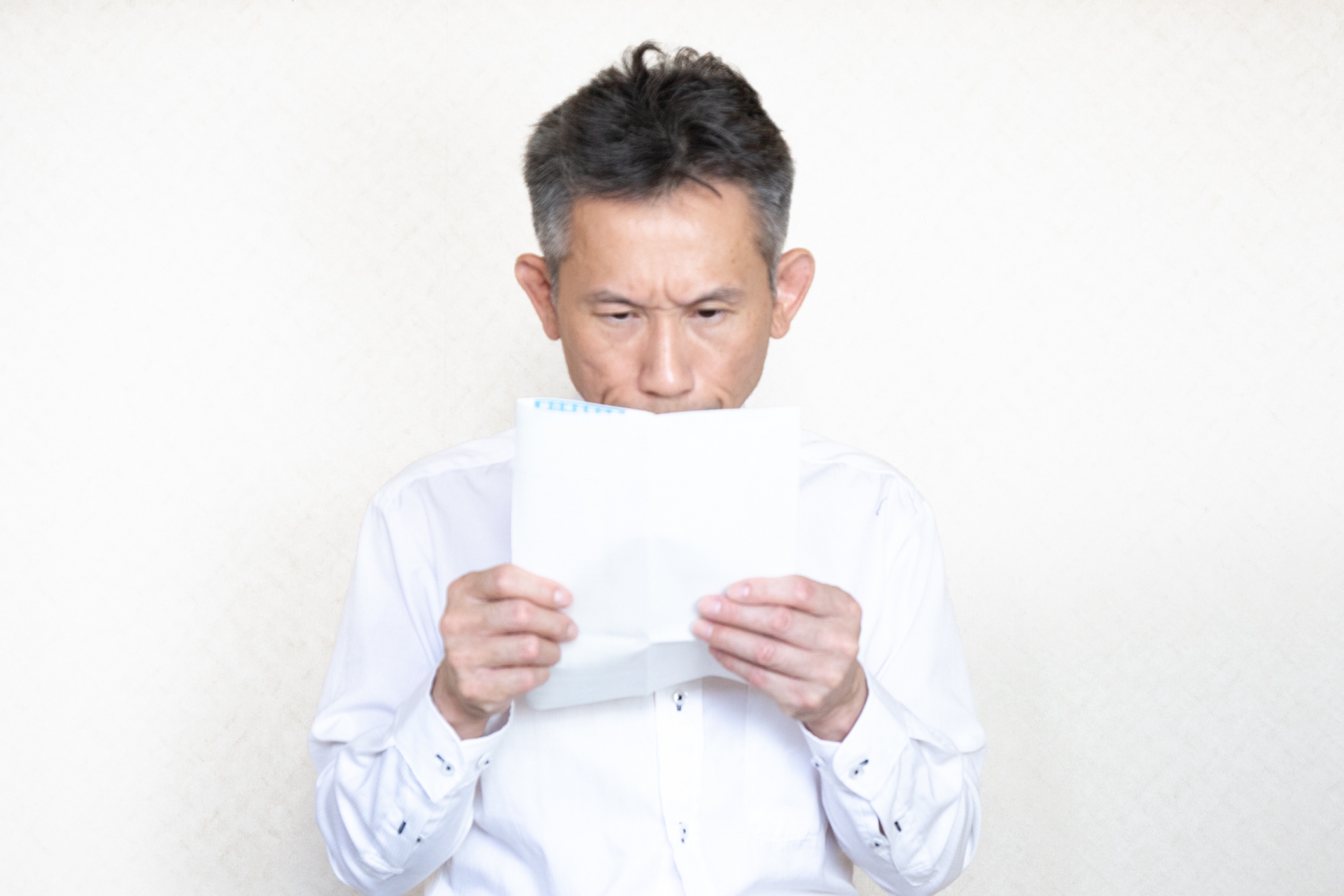 書類をのぞき込む中高年男性