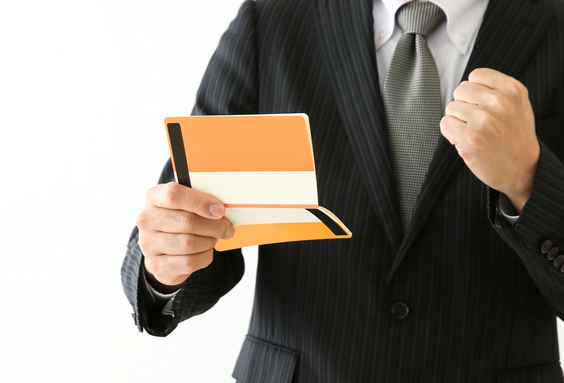 通帳を見てガッツポーズをするビジネスマン