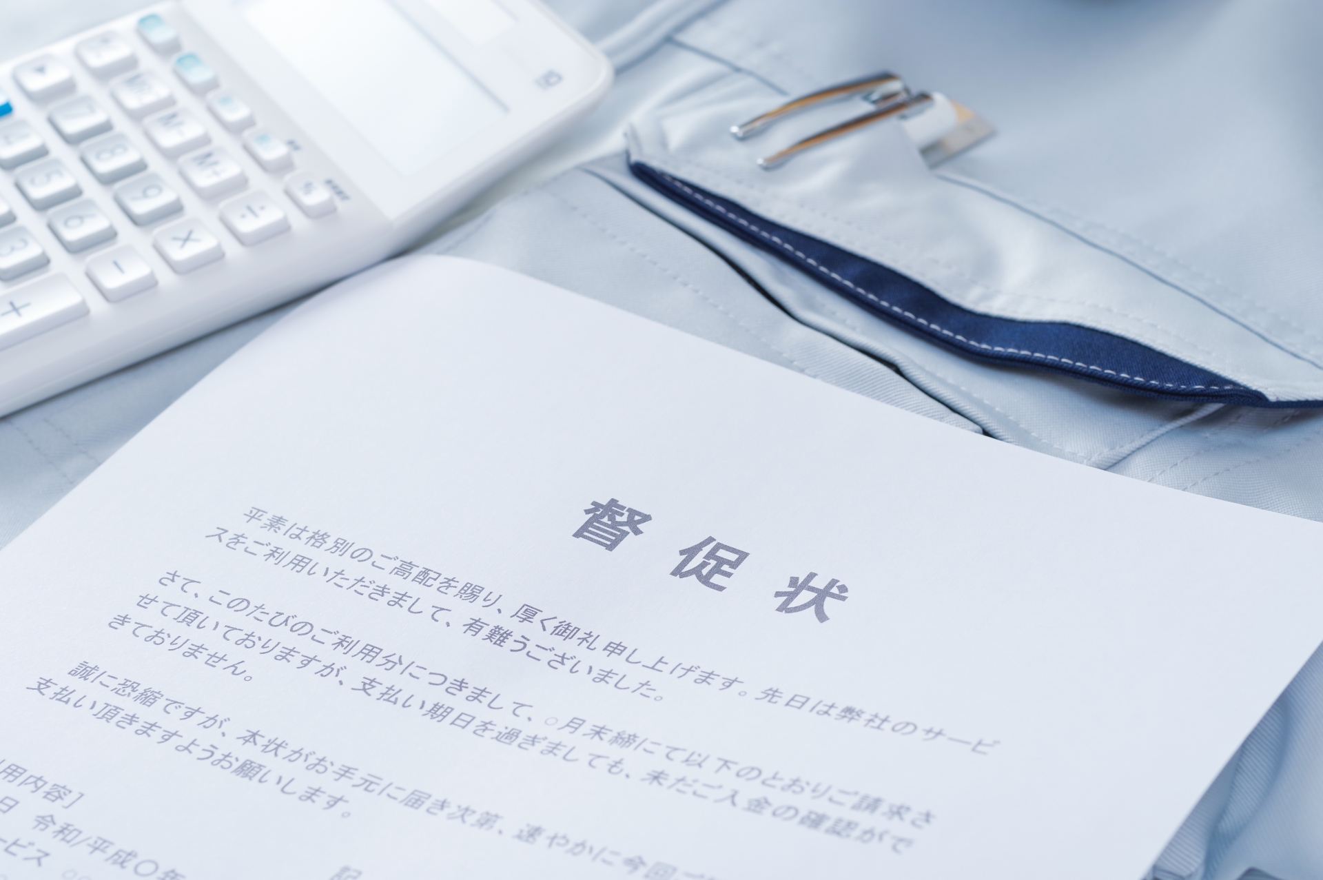 作業服の上に置かれた督促状