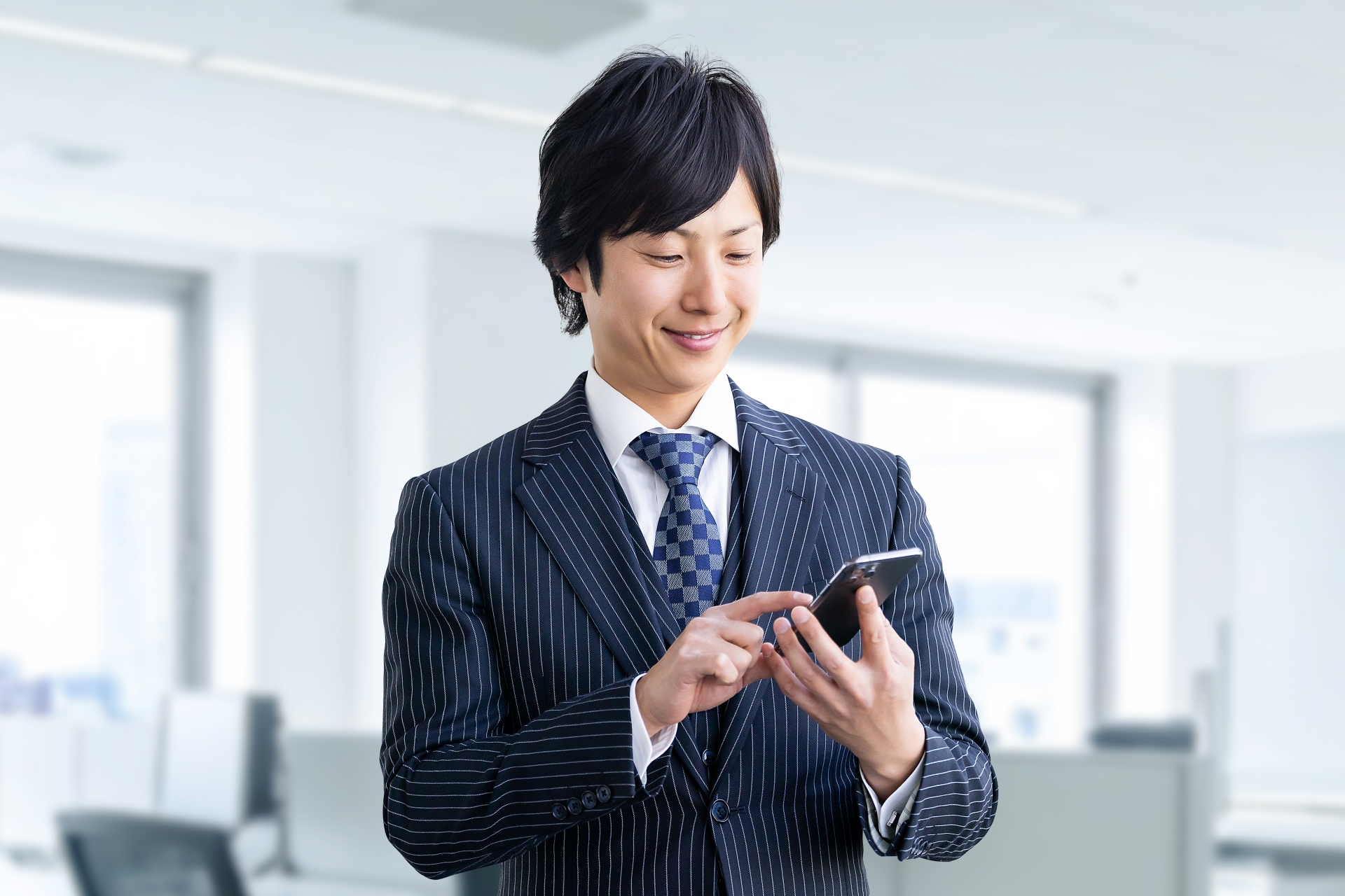 スマホを操作するスーツの男性