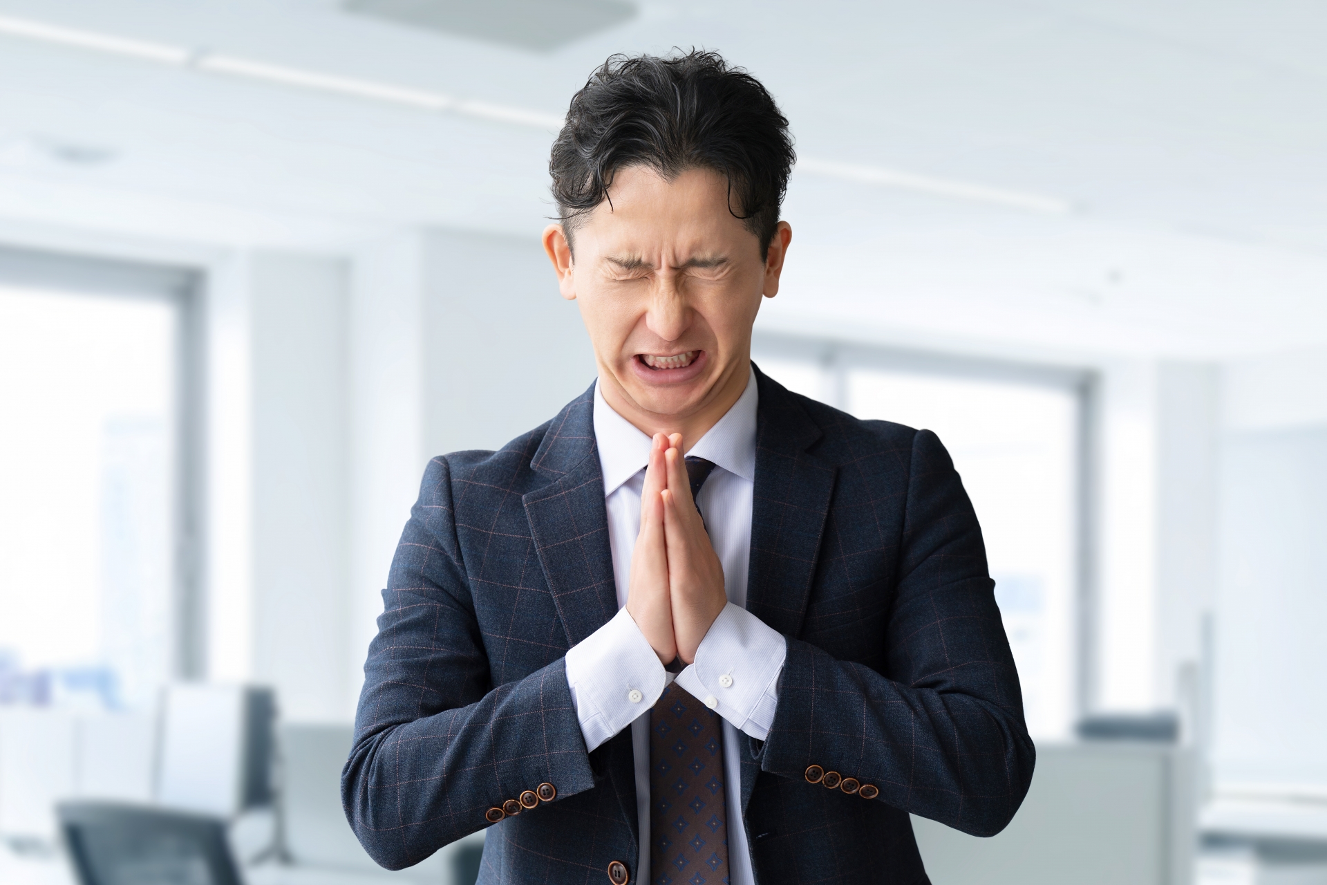 お願い・謝るポーズの男性ビジネスマン