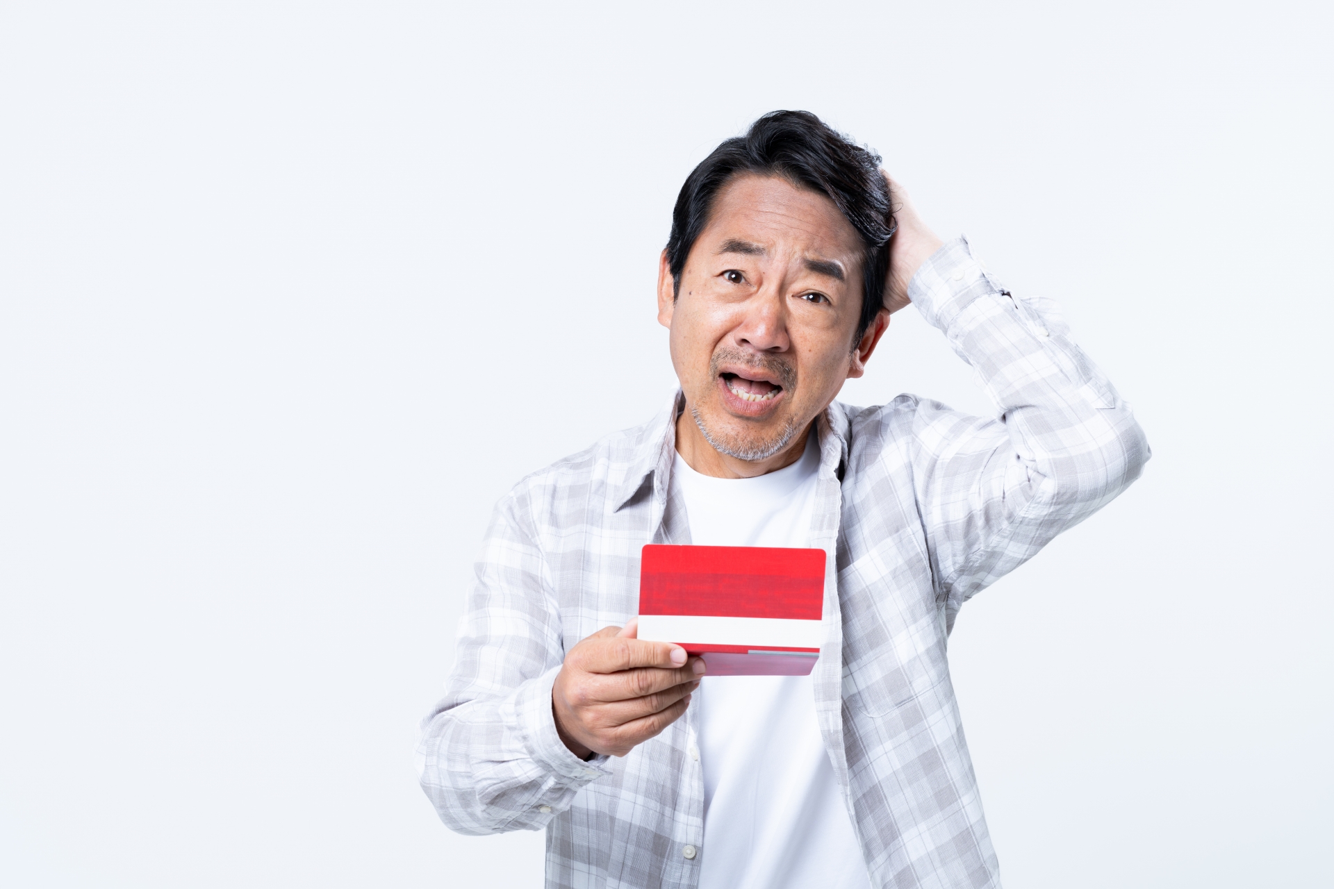 通帳で悩むミドルの男性