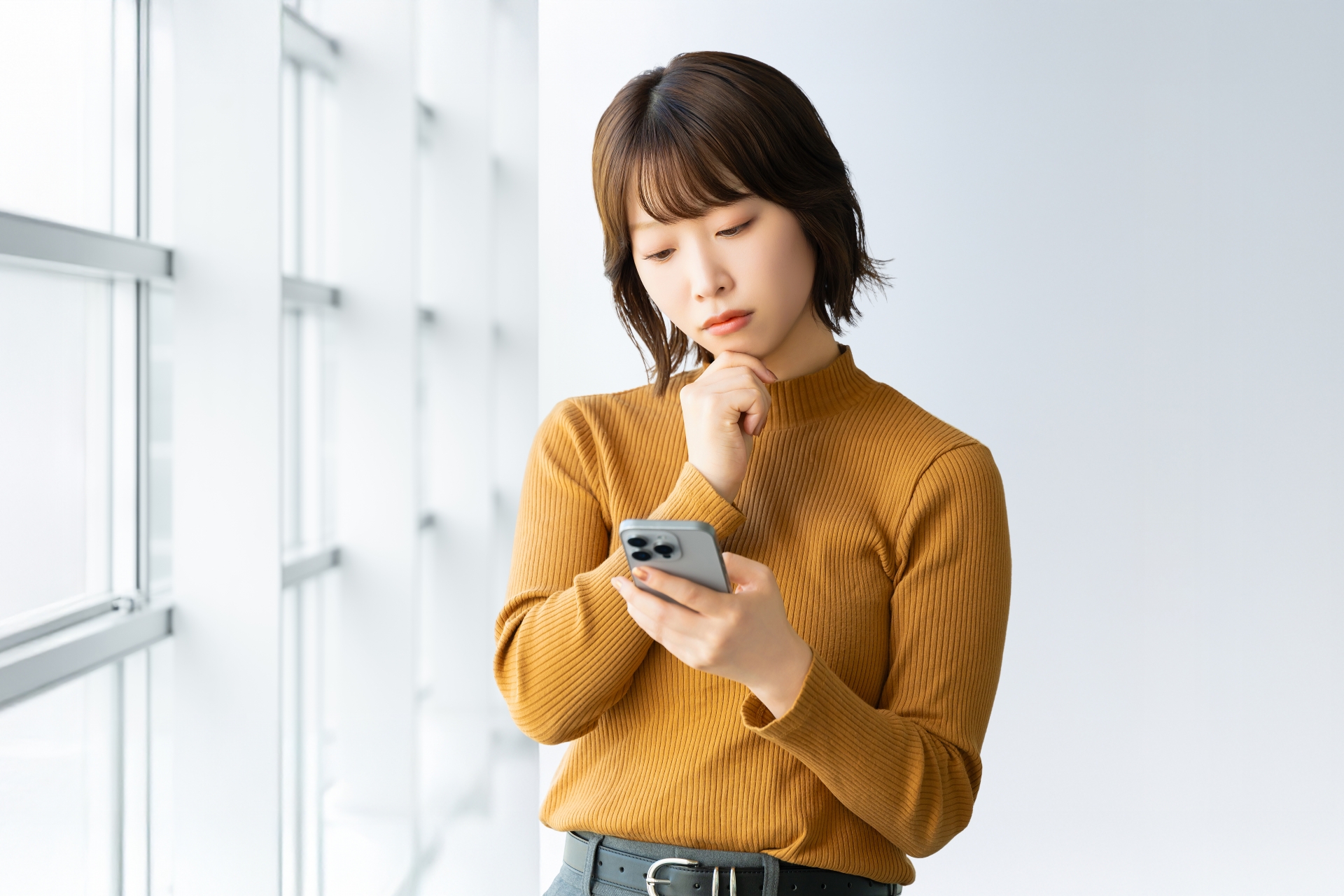 スマホを見て考える女性