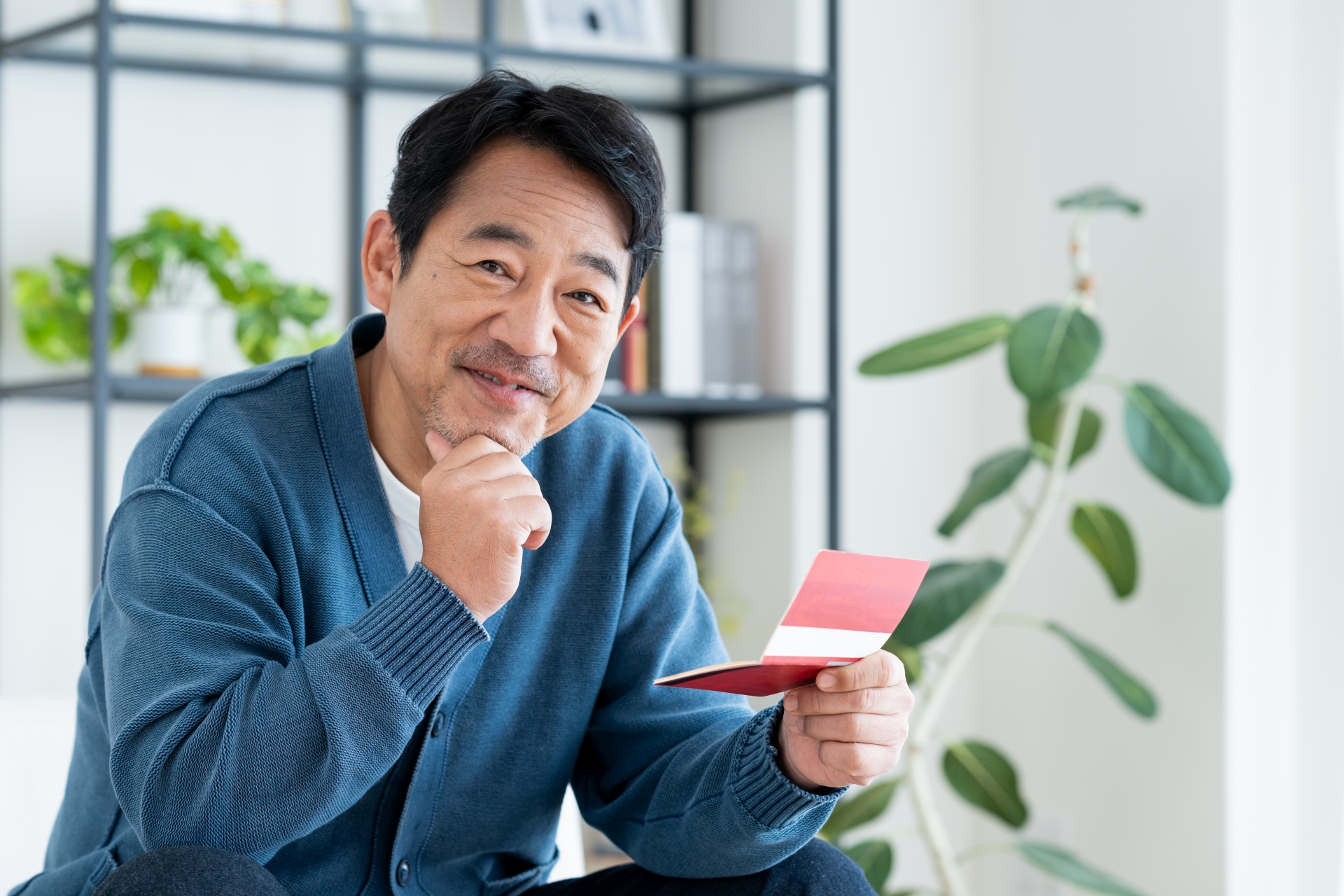 通帳を持つミドルの男性