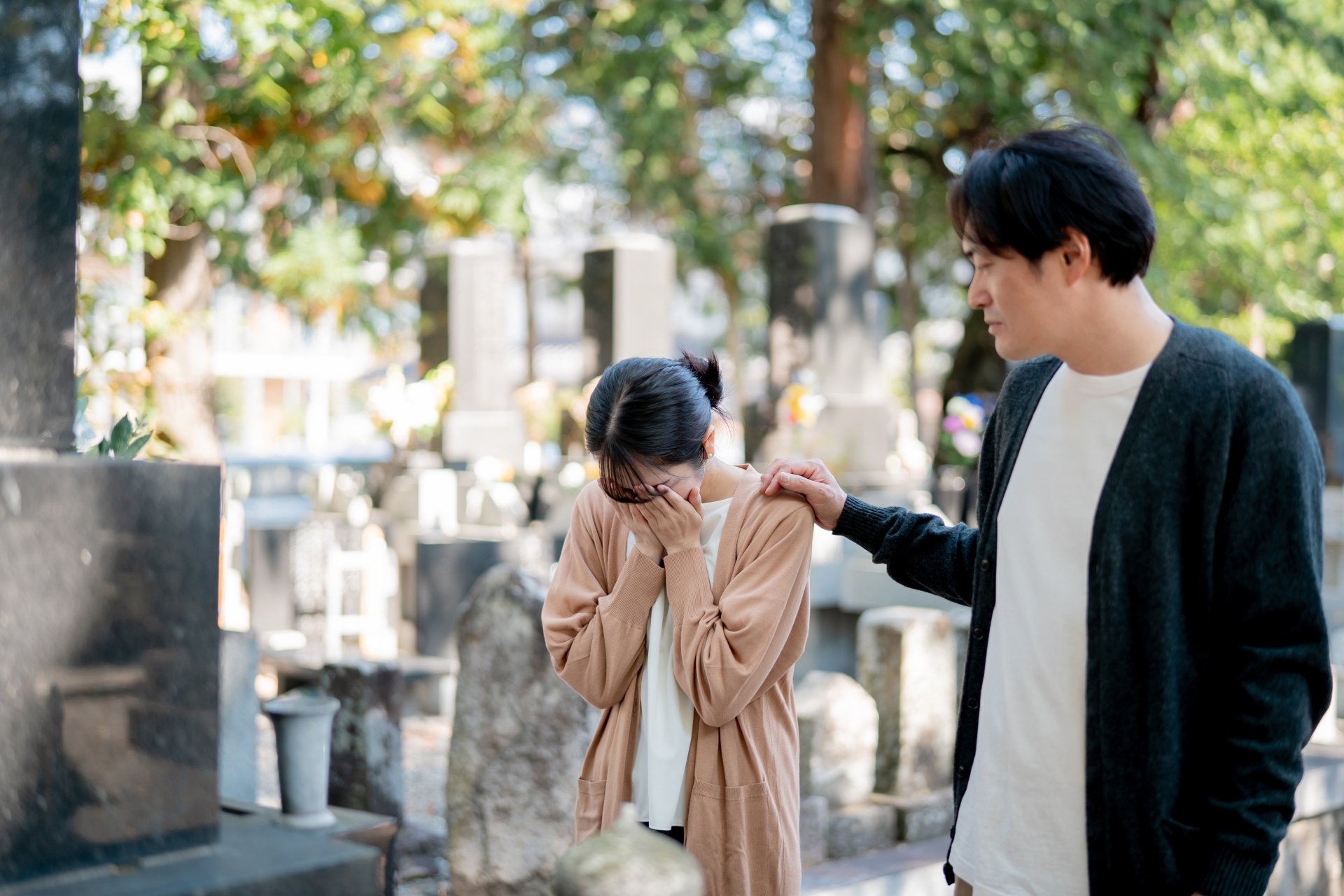 墓地で泣く女性