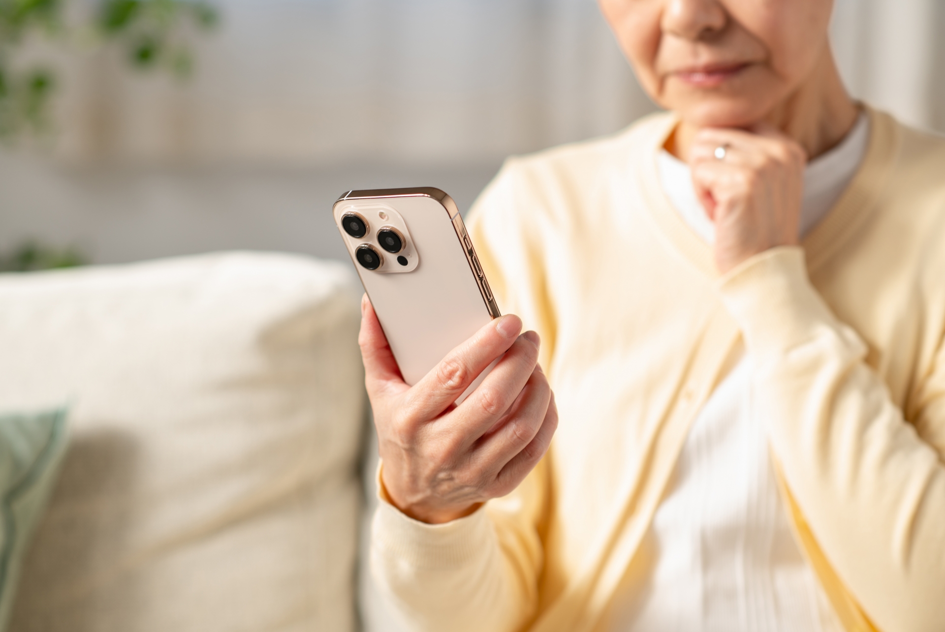 スマホを見て考えるシニアの女性