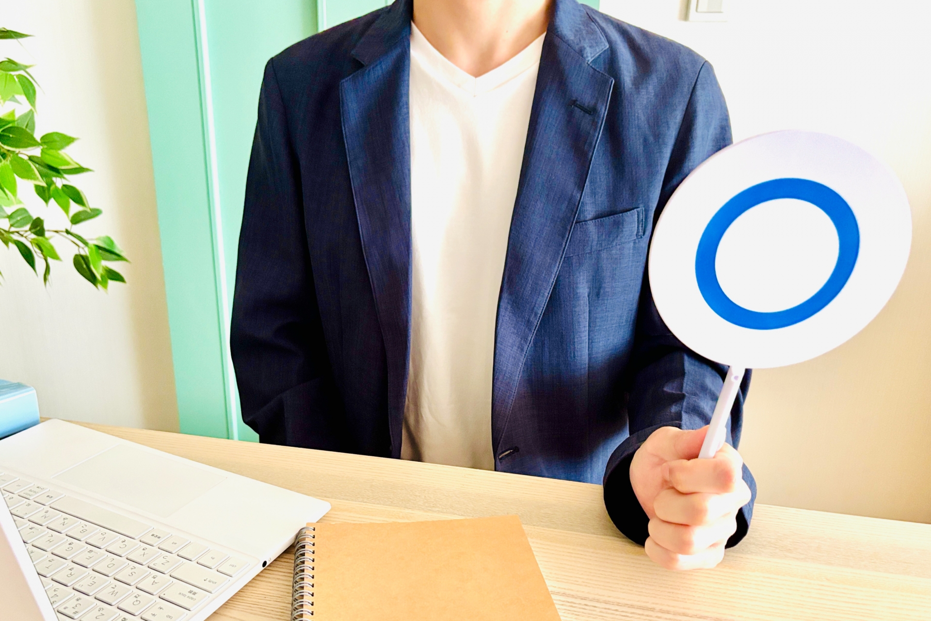 丸の札を持つ男性