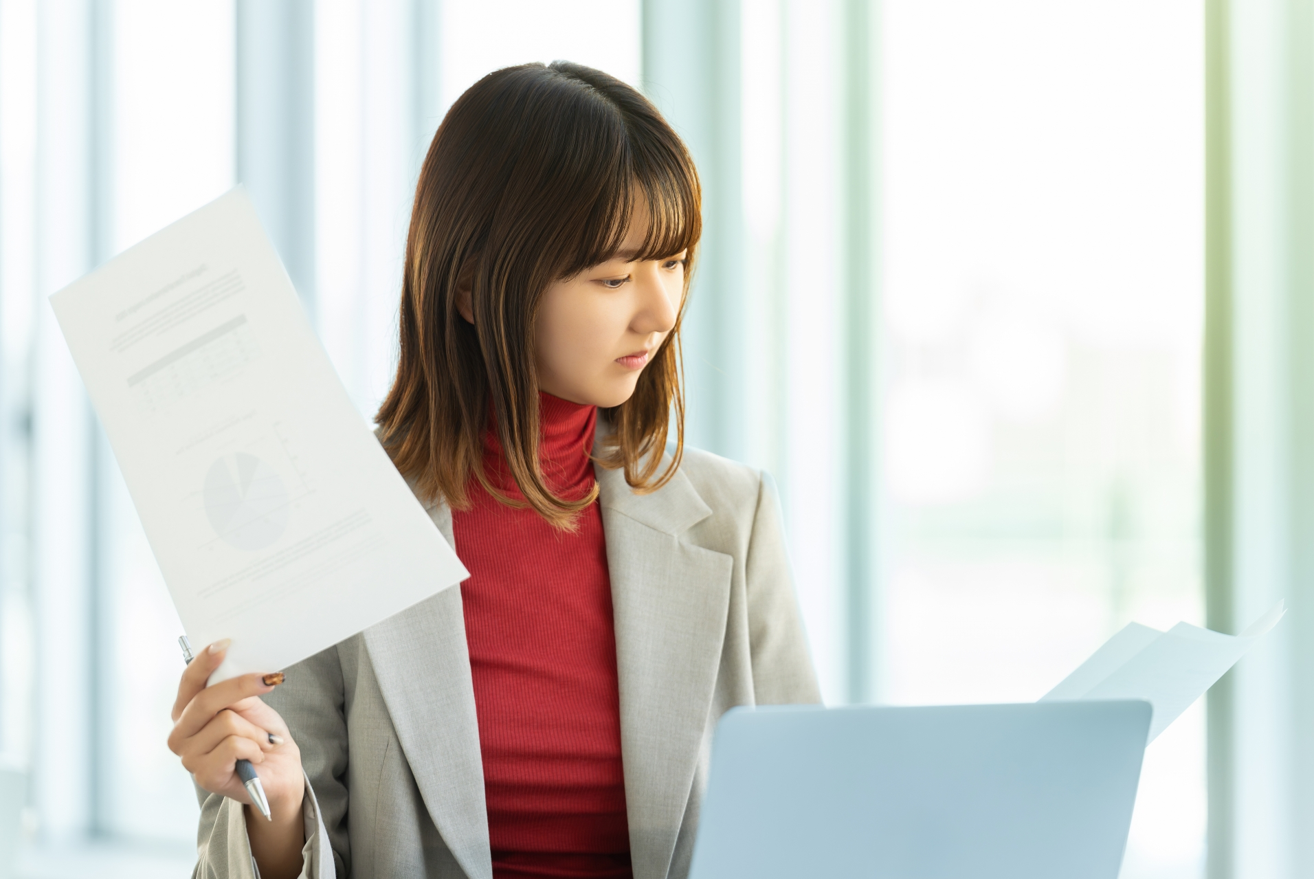 書類に目を通すスーツの女性