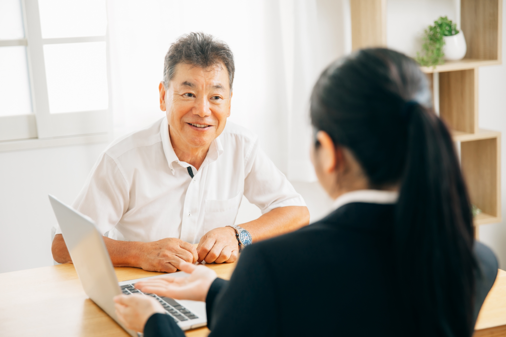 打ち合わせするスーツ姿の女性と高齢者男性