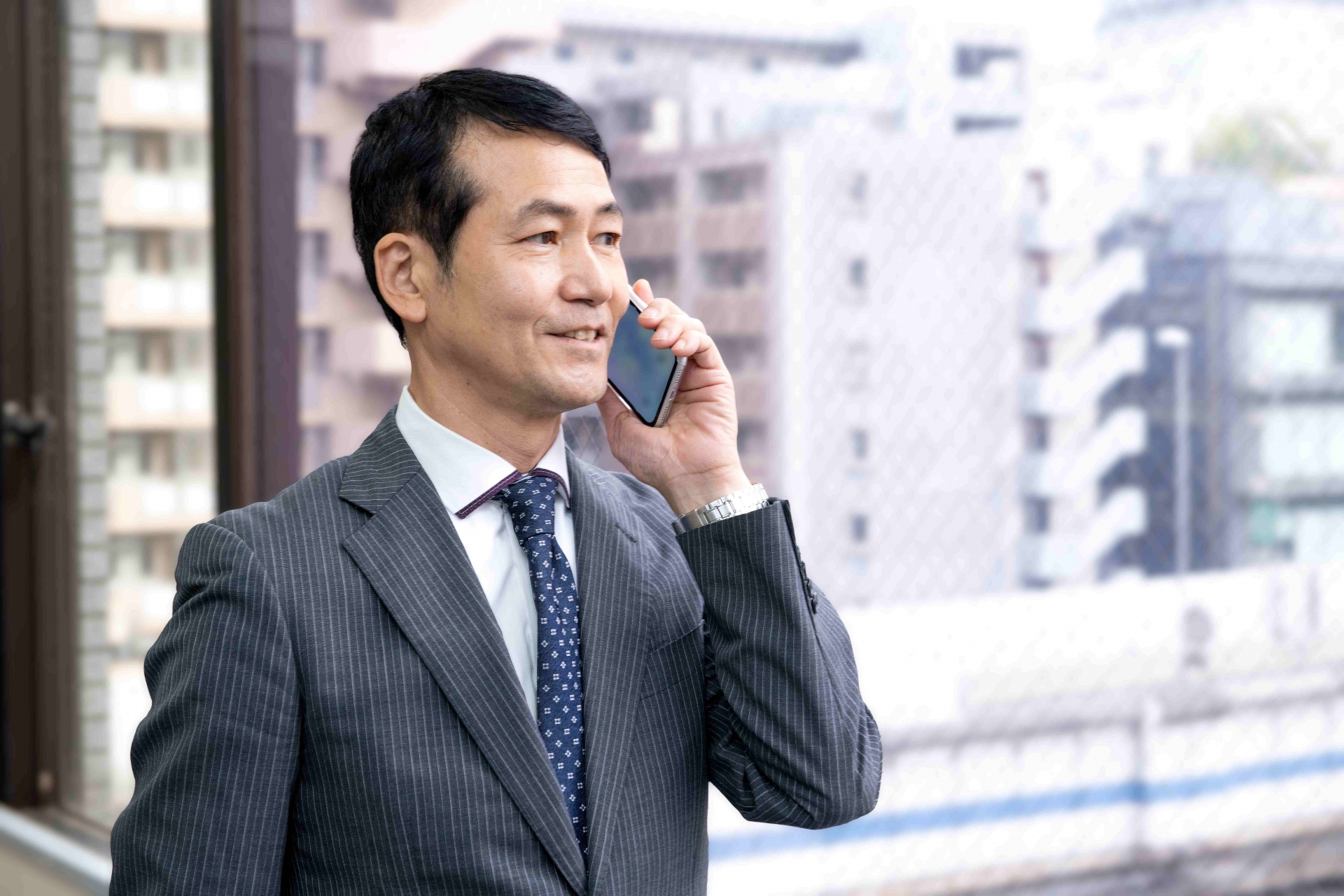 スマホで通話するスーツの男性