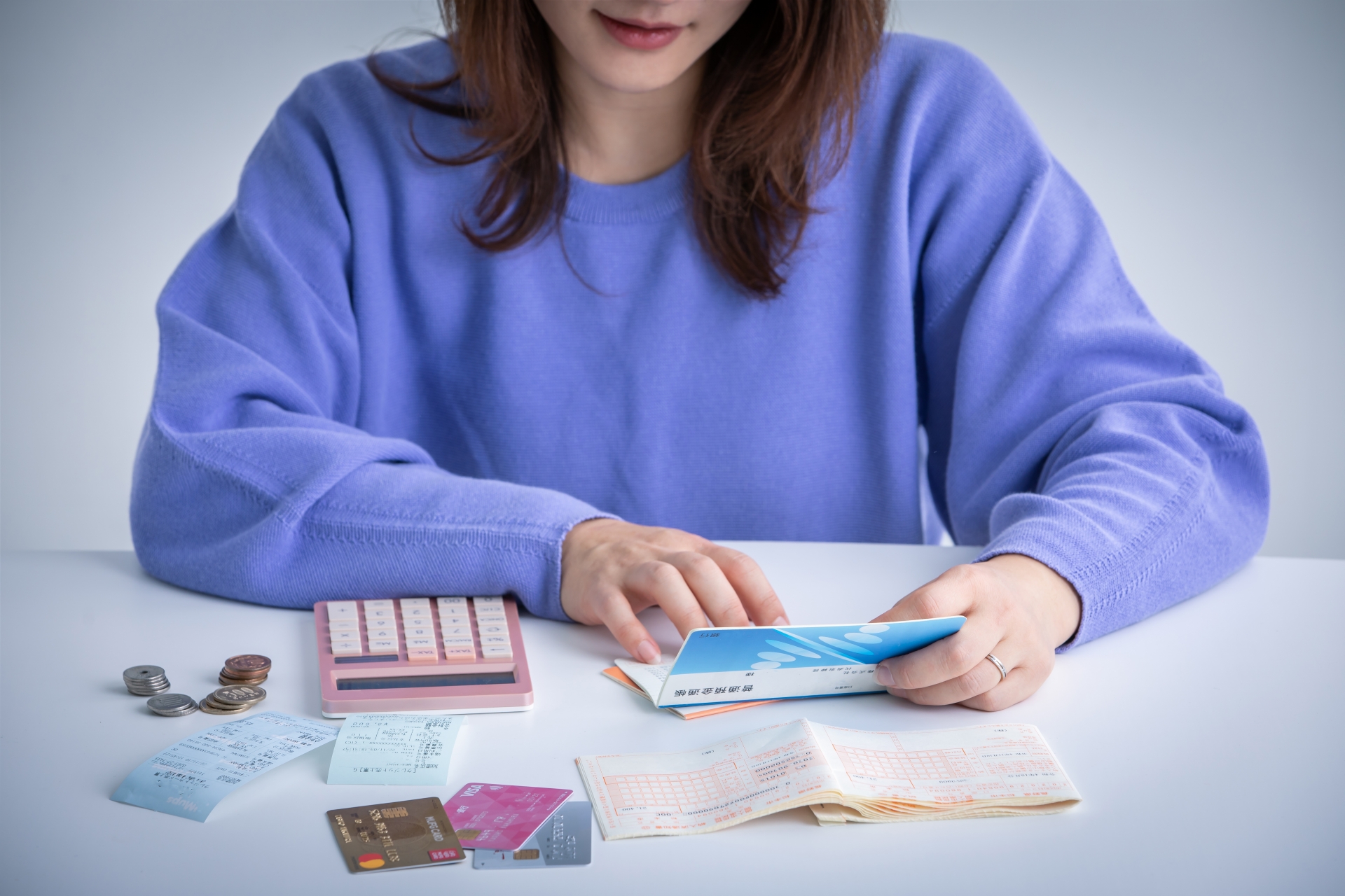 通帳を見てお金の計算をする女性