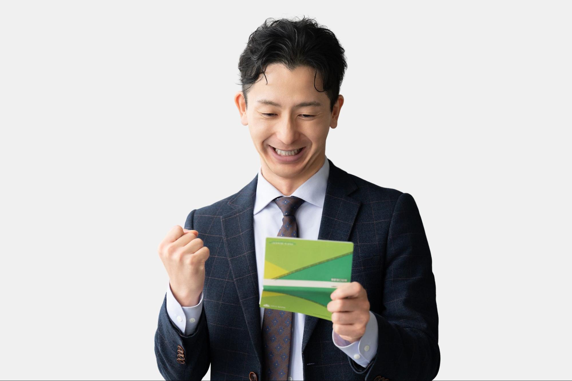 通帳を見てガッツポーズする男性