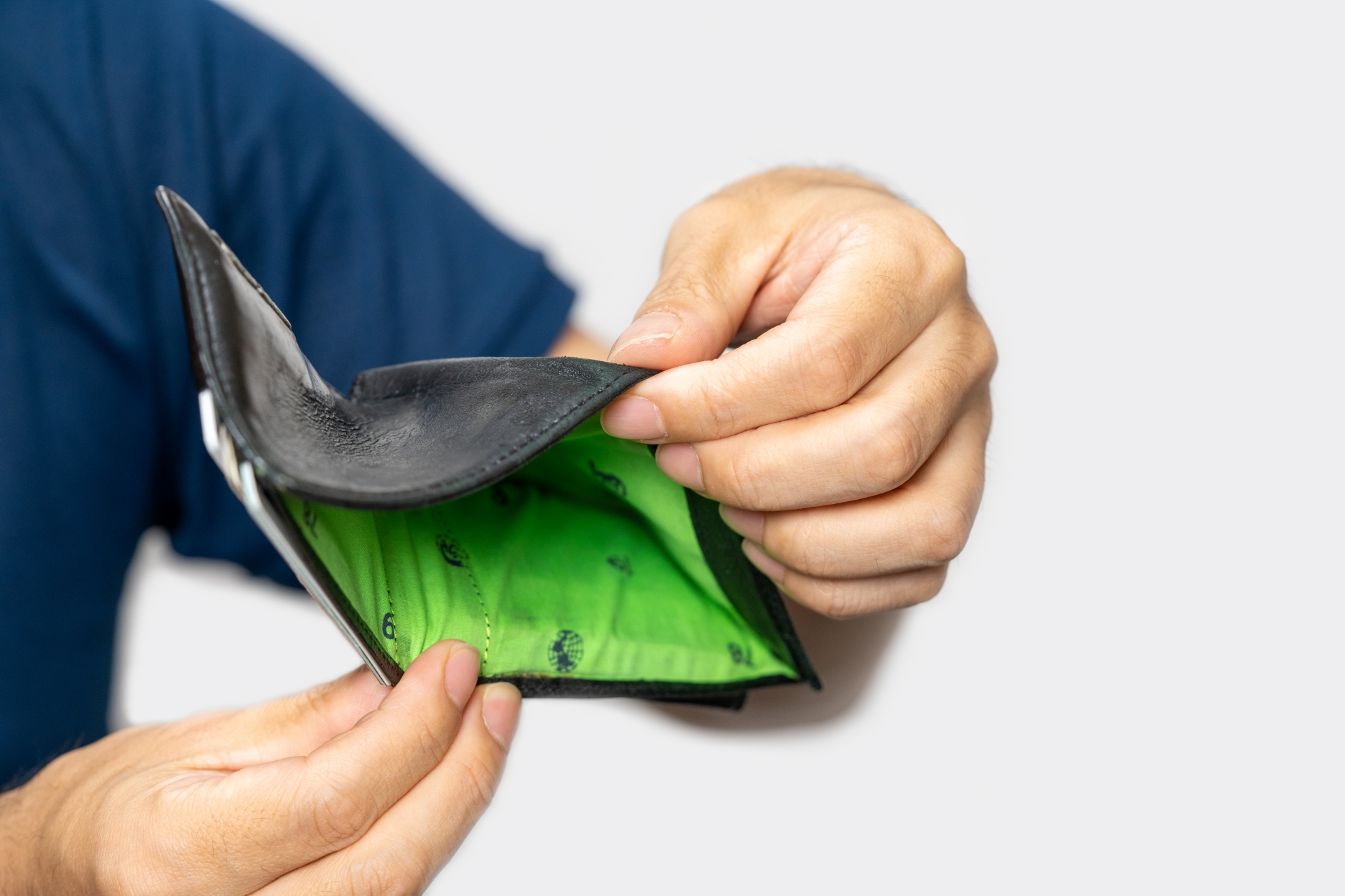 空っぽの財布の中を確認する男性