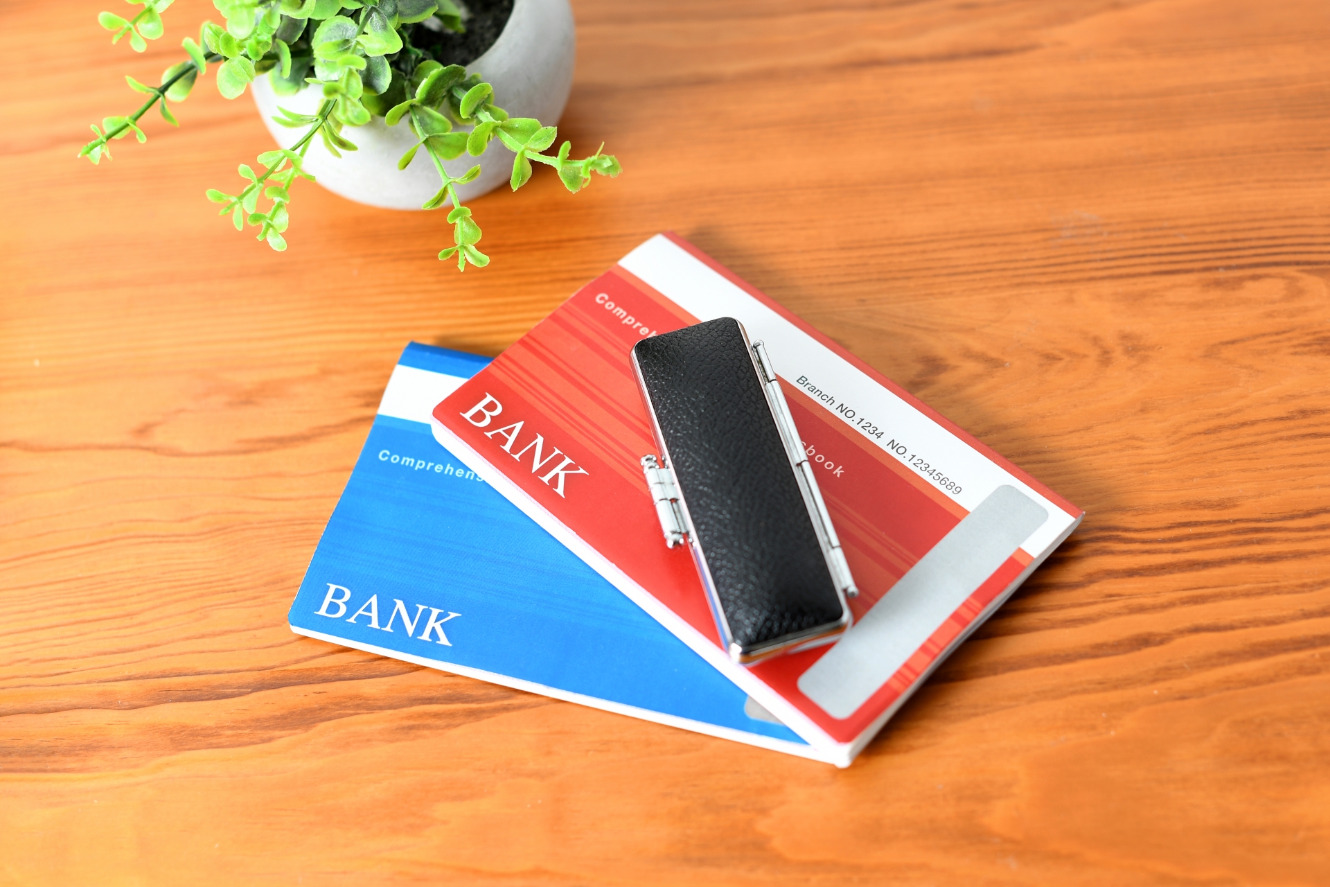 机に置かれた銀行通帳と印鑑のイメージ