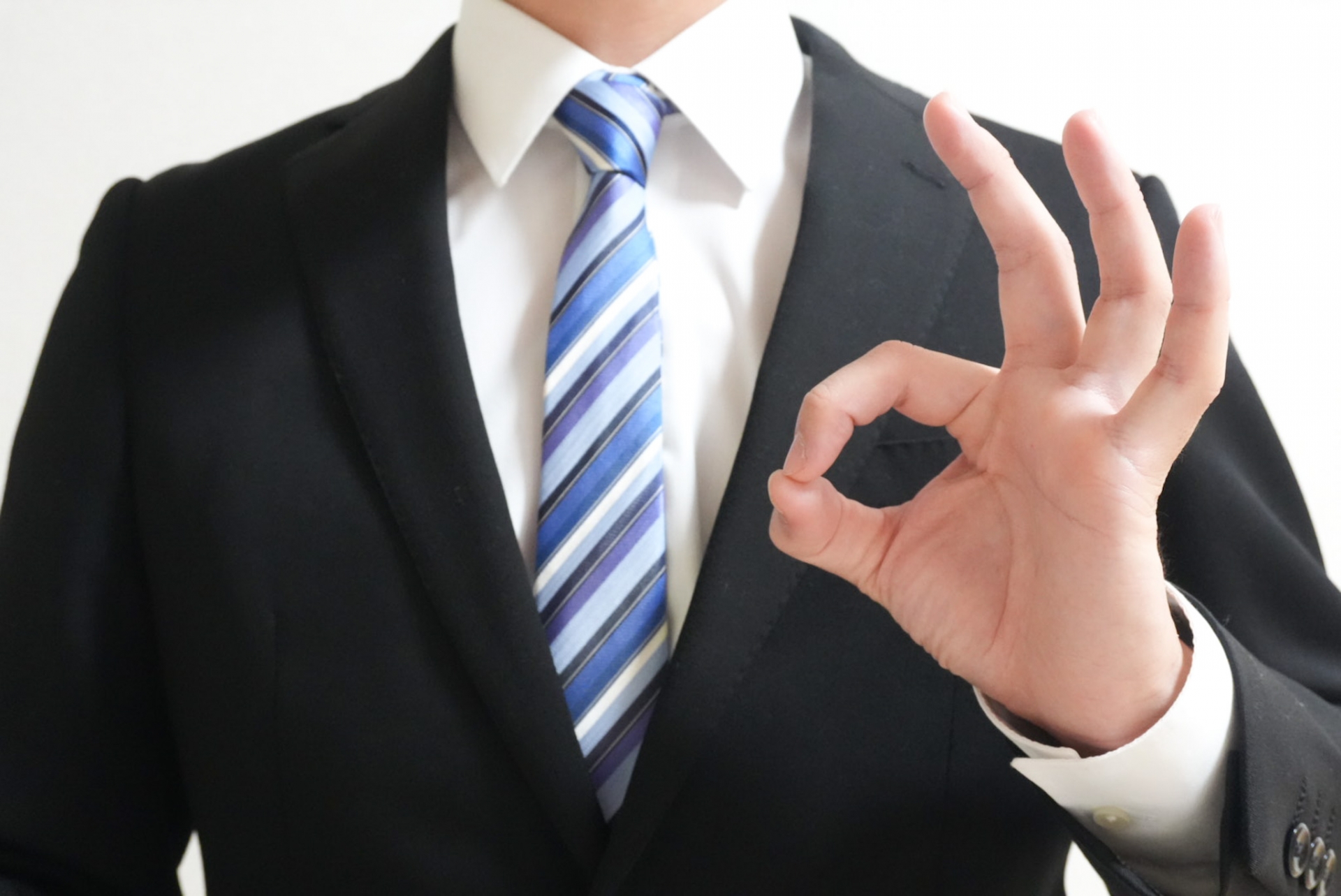 OKサインをするスーツの男性