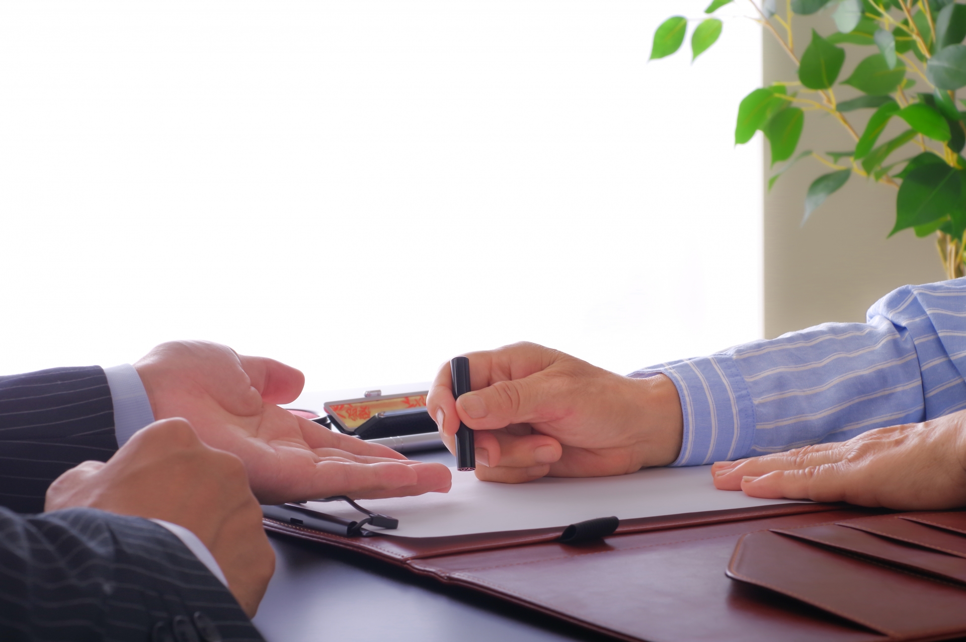 書類に印鑑を押す女性と促す男性の手元