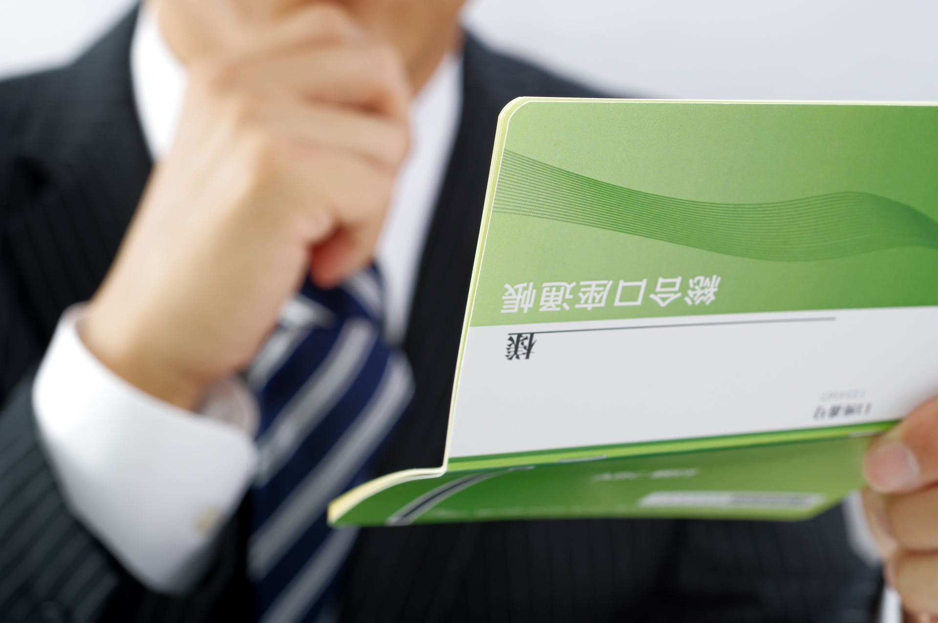 通帳を見るサラリーマン