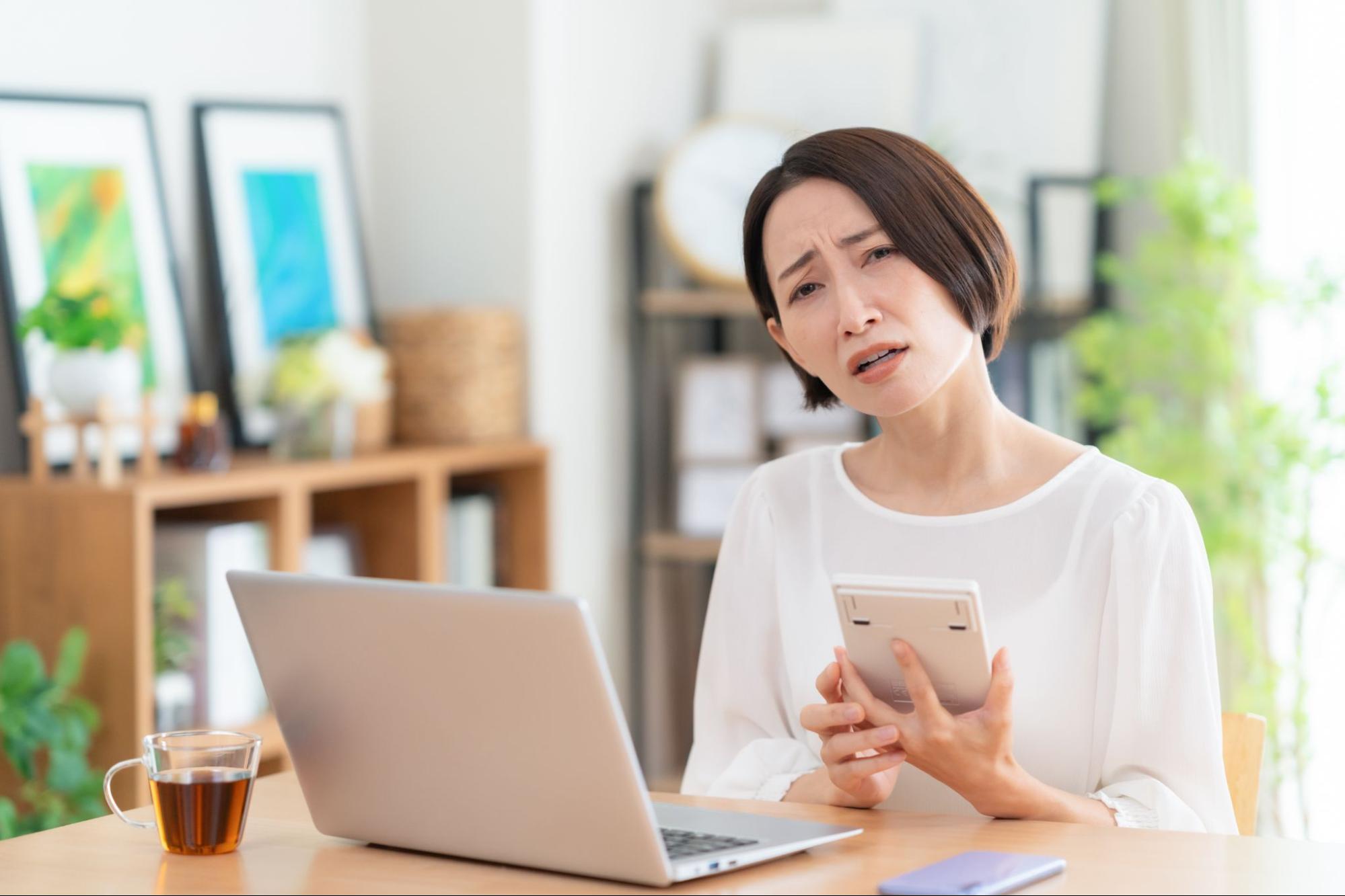 リビングで家計簿をつけるミドルの女性