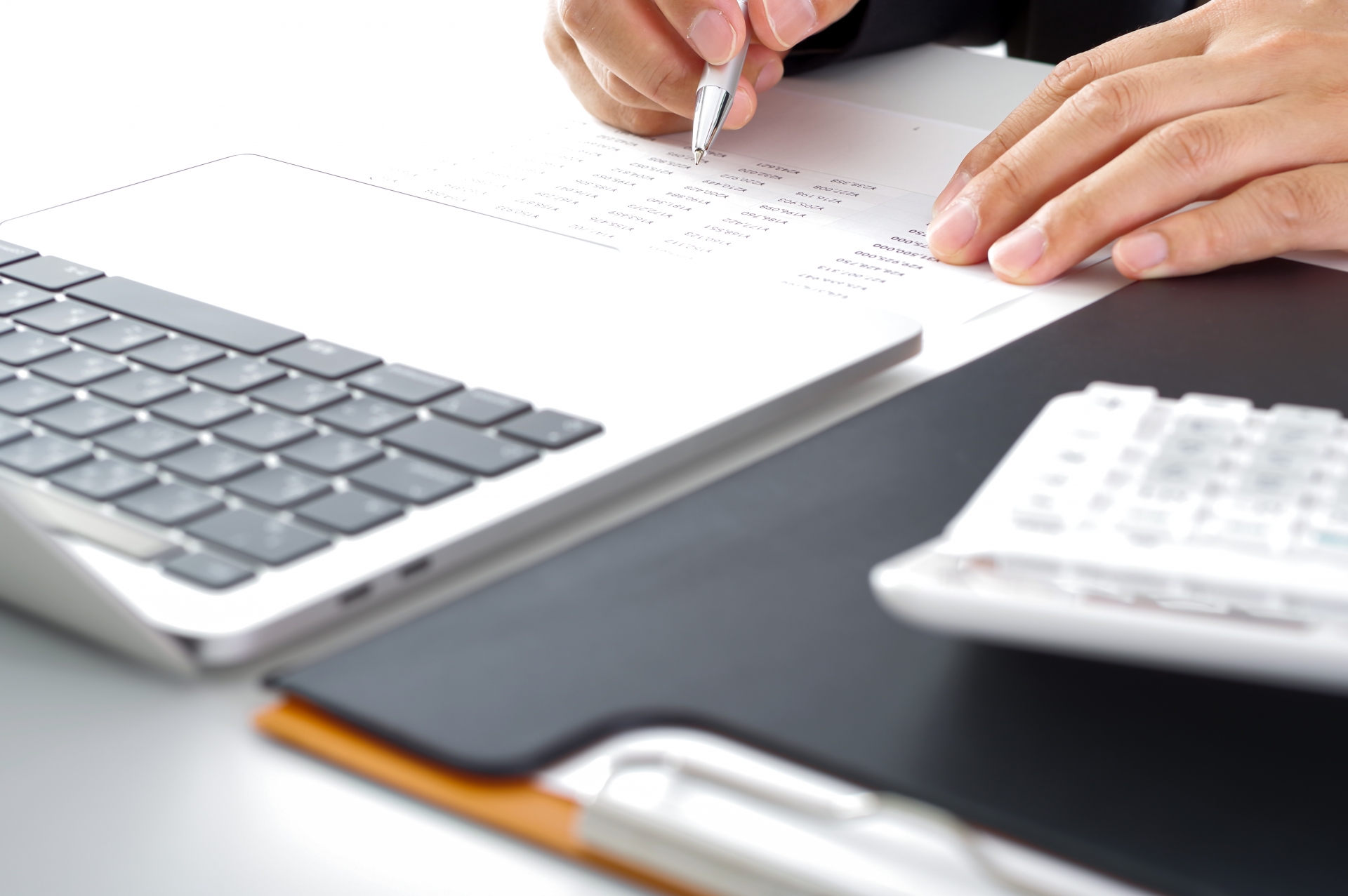 書類をチェックする男性の手元