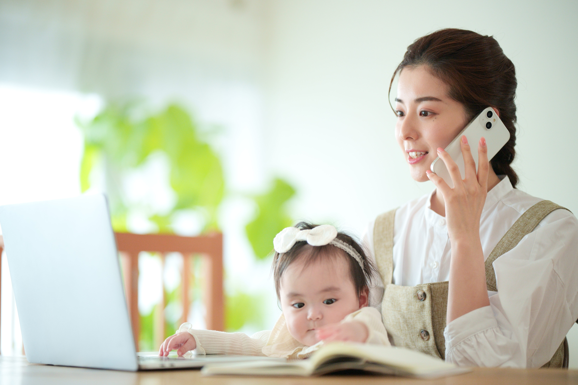 パソコンを見ながら電話する女性