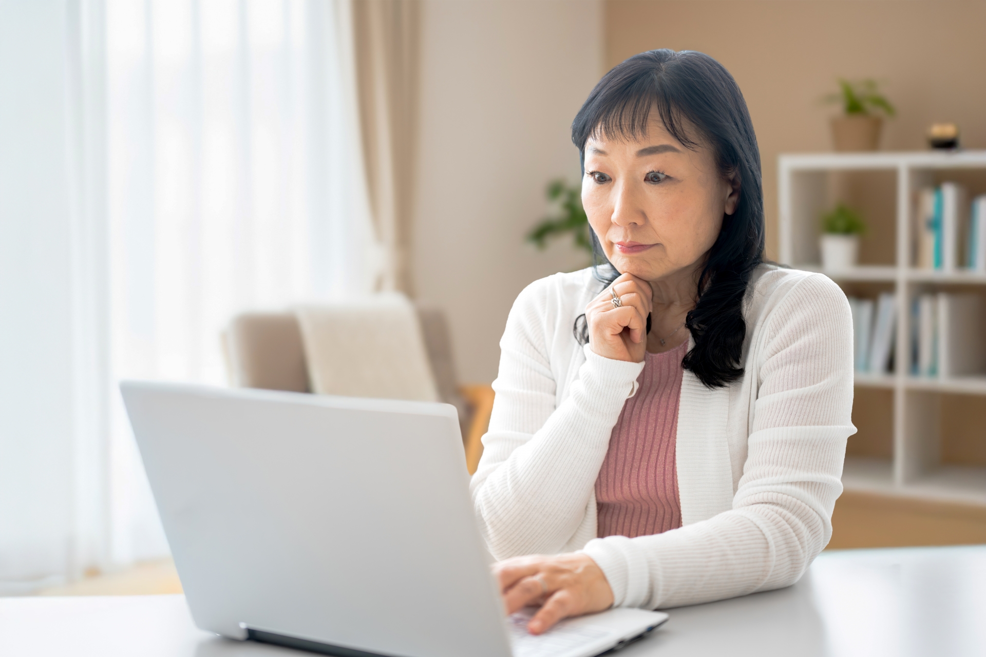 パソコンを見て驚くミドルの女性