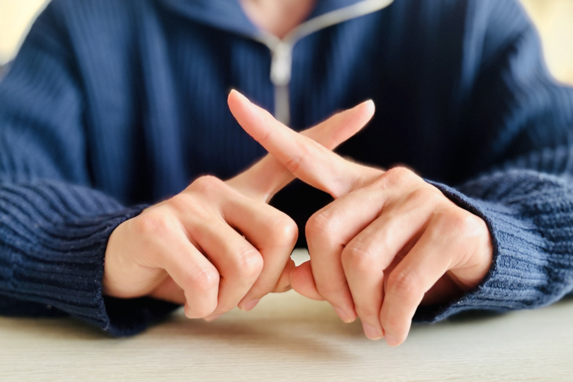指でバツサインをする人