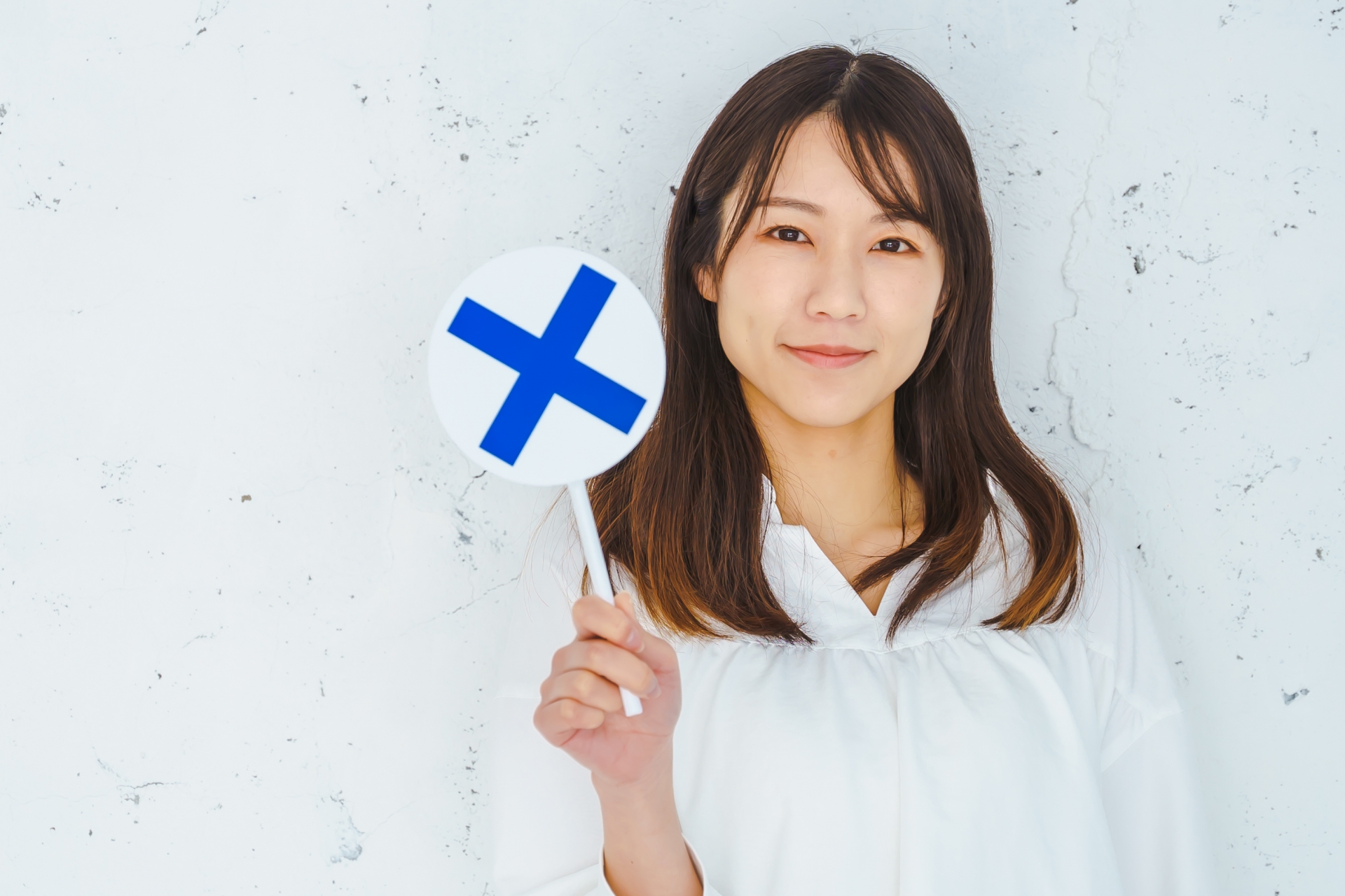 バツサインを持つ女性