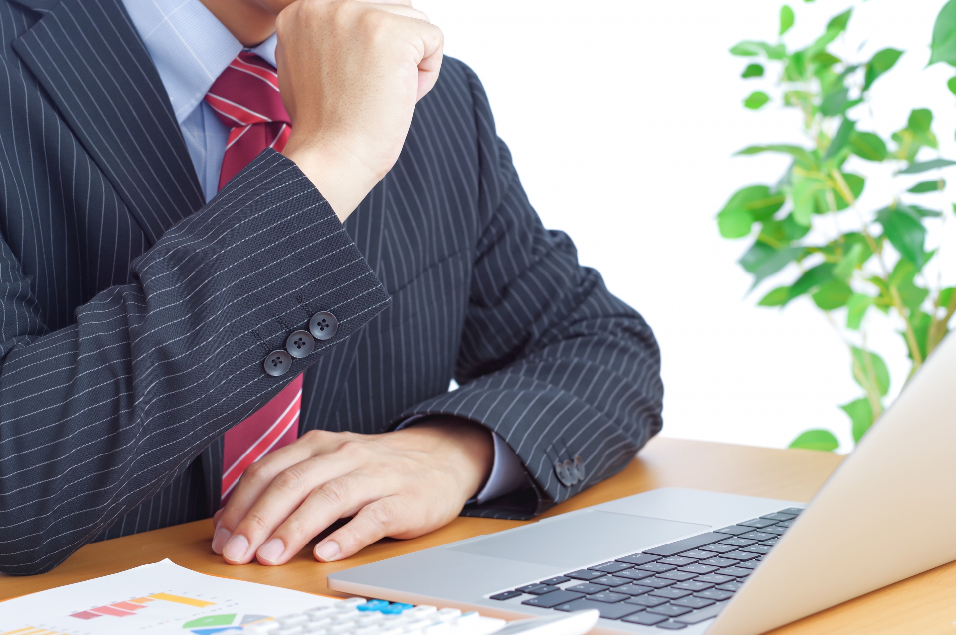 パソコンの前で考え事をしている男性