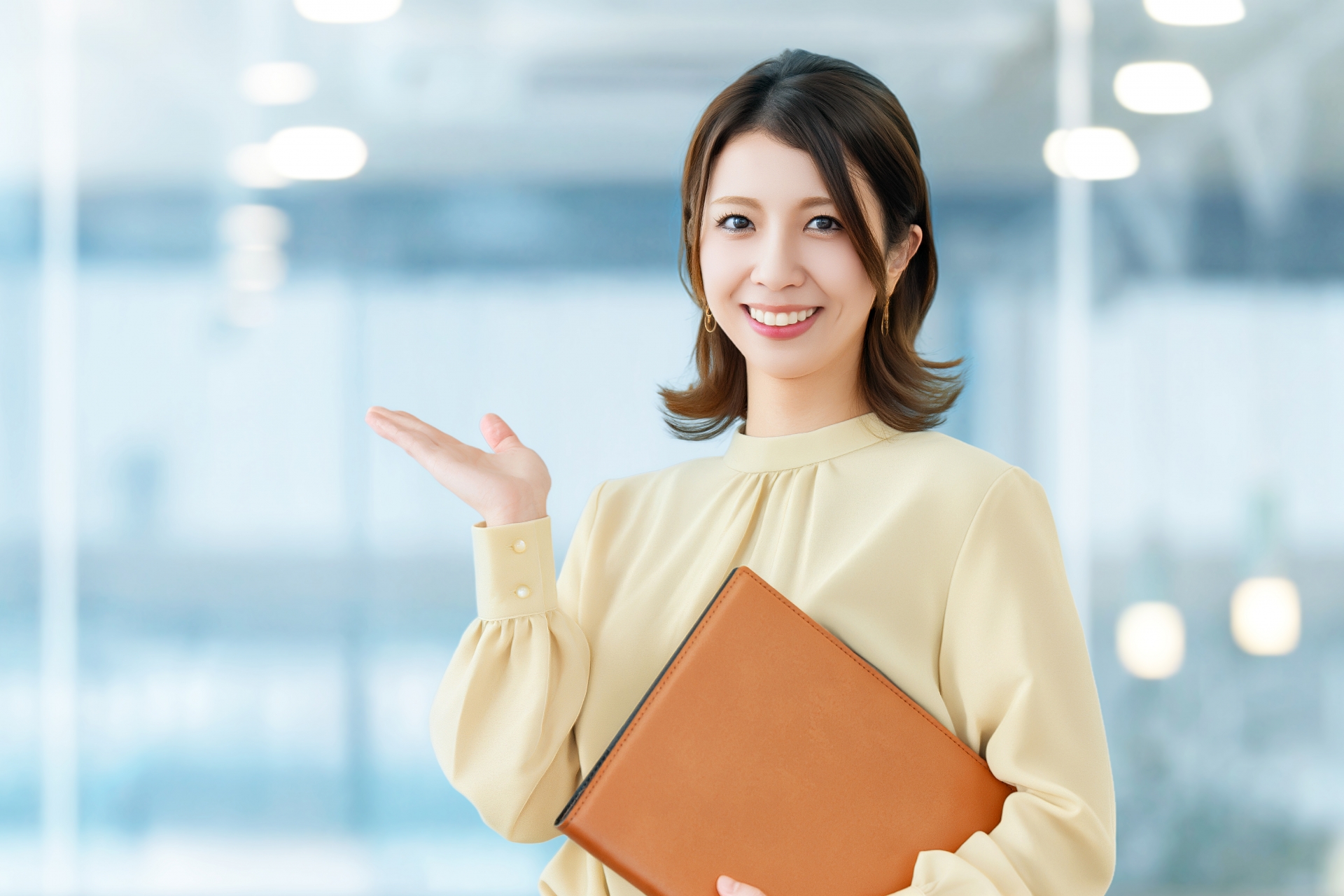 手のひらを上に向けて案内する女性