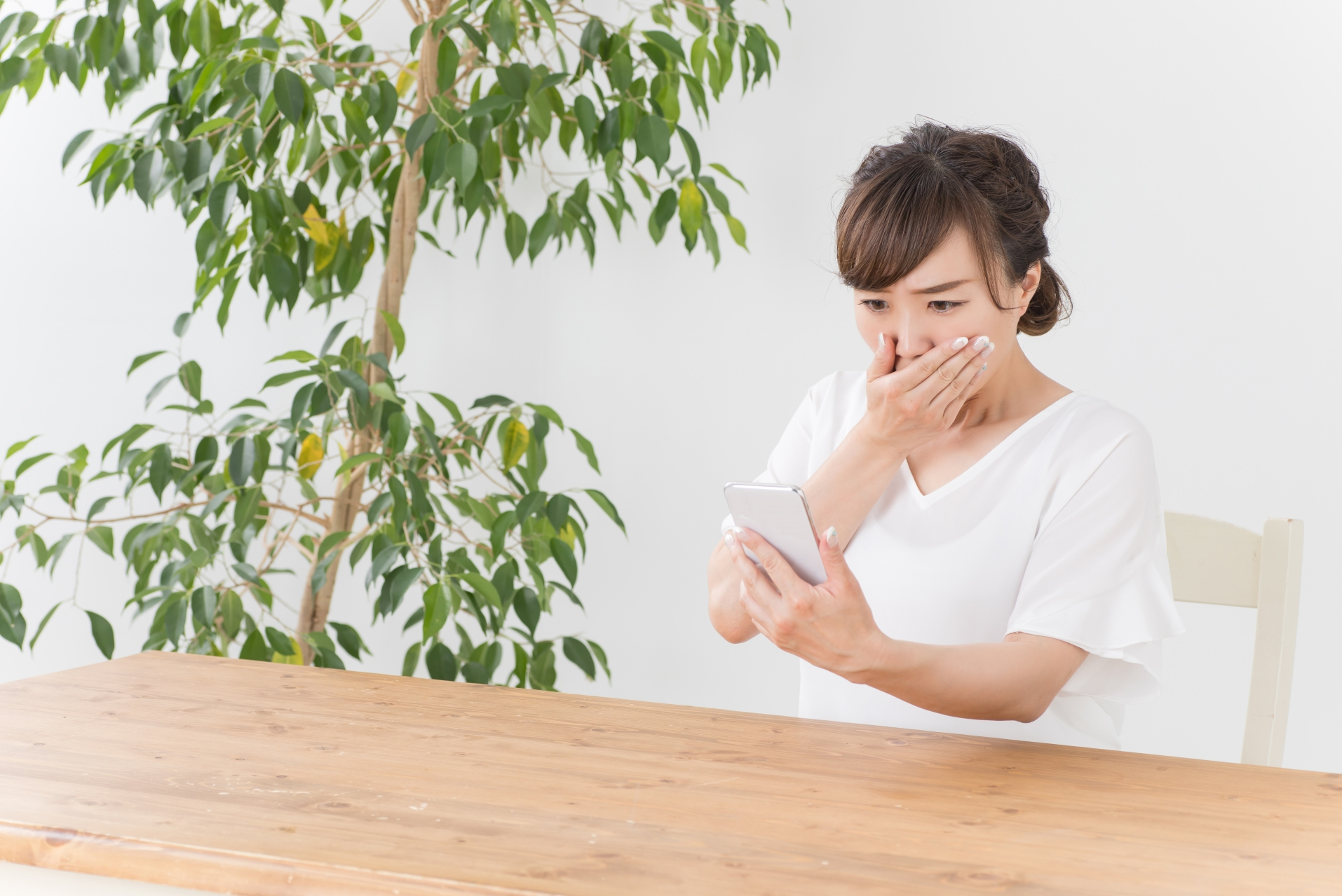 スマホを見て驚く女性