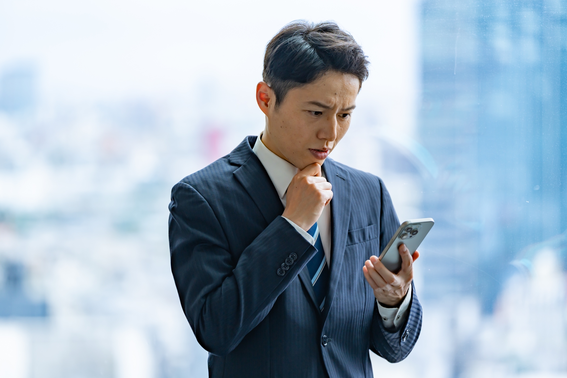 スマホを見て悩む男性
