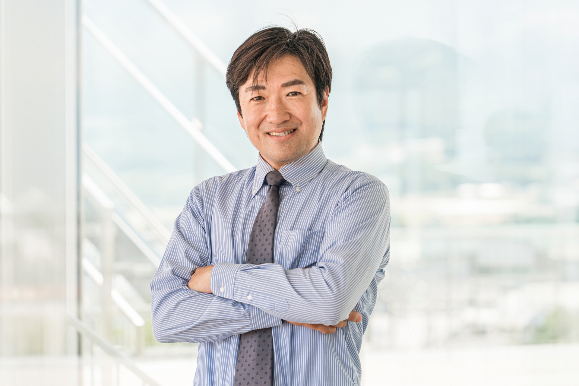 オフィスビルで腕組みする中年ビジネスマン