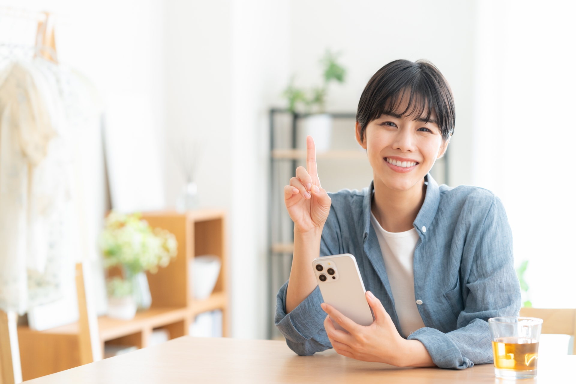 リビングでスマホを見る若い女性