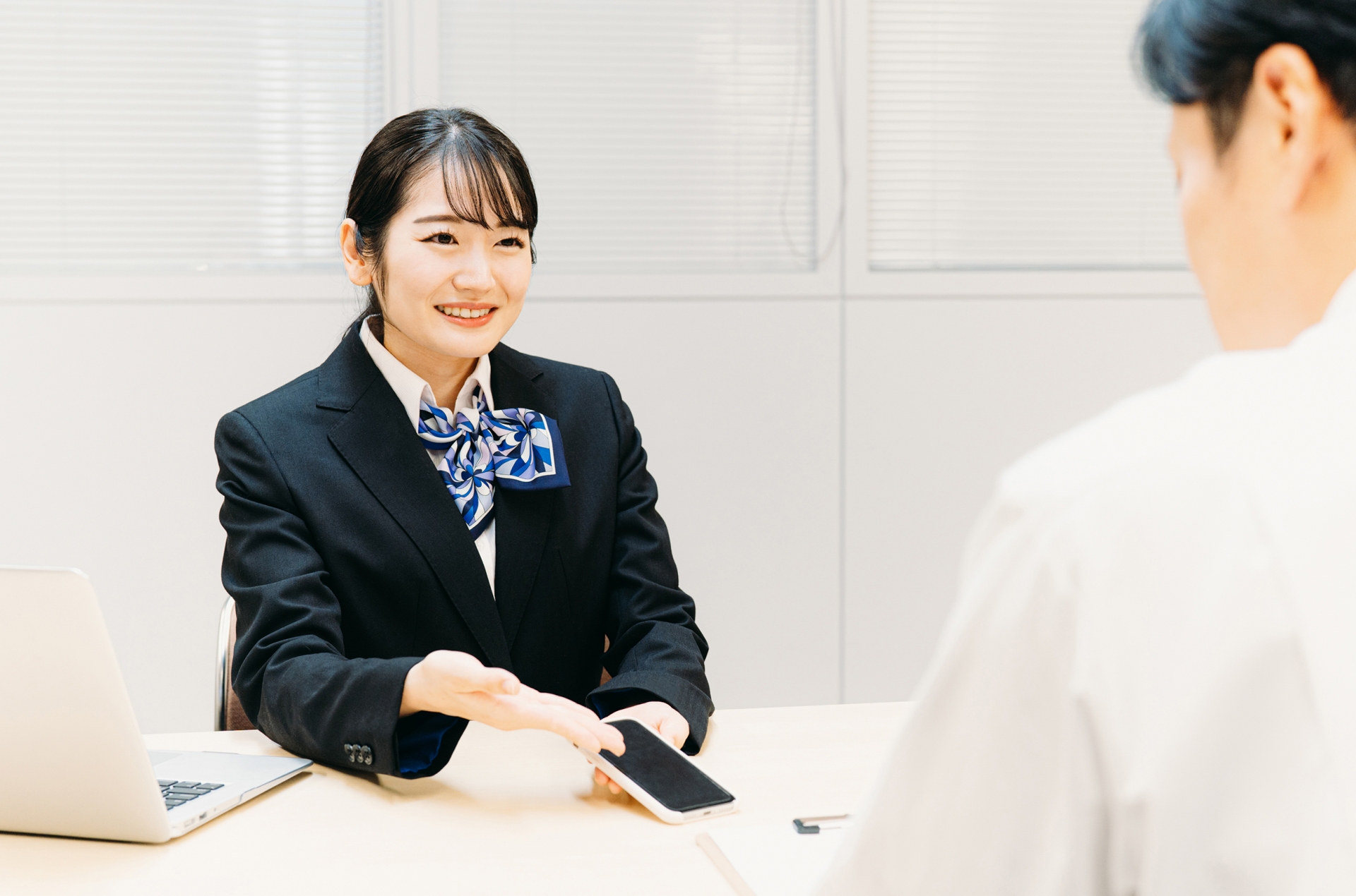 スマホの説明をする女性（携帯ショップ）