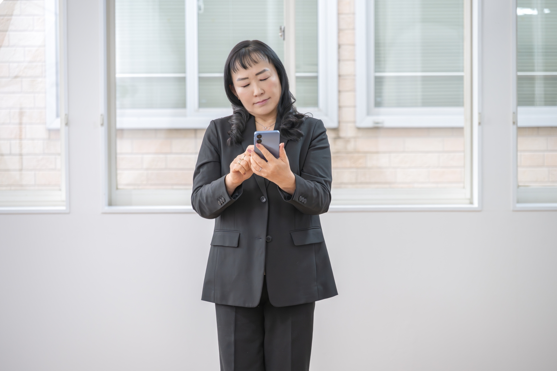 スマホを見て悩む女性
