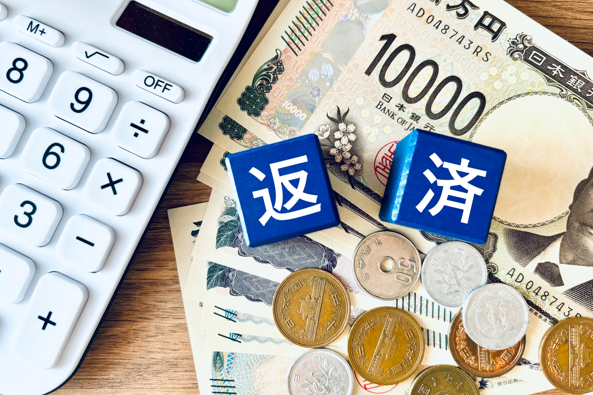 返済の文字と電卓、現金