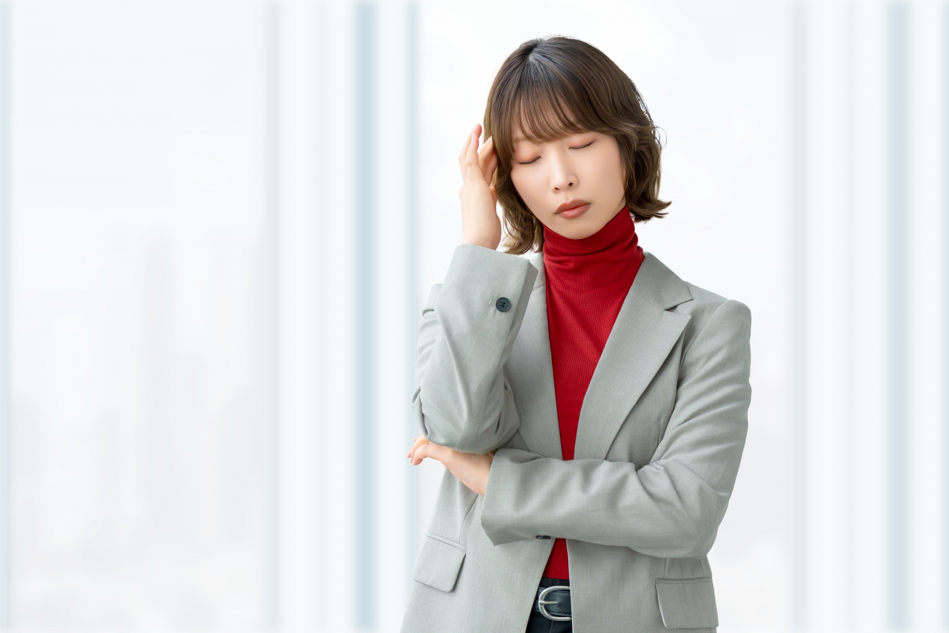 悩むグレーのスーツの女性