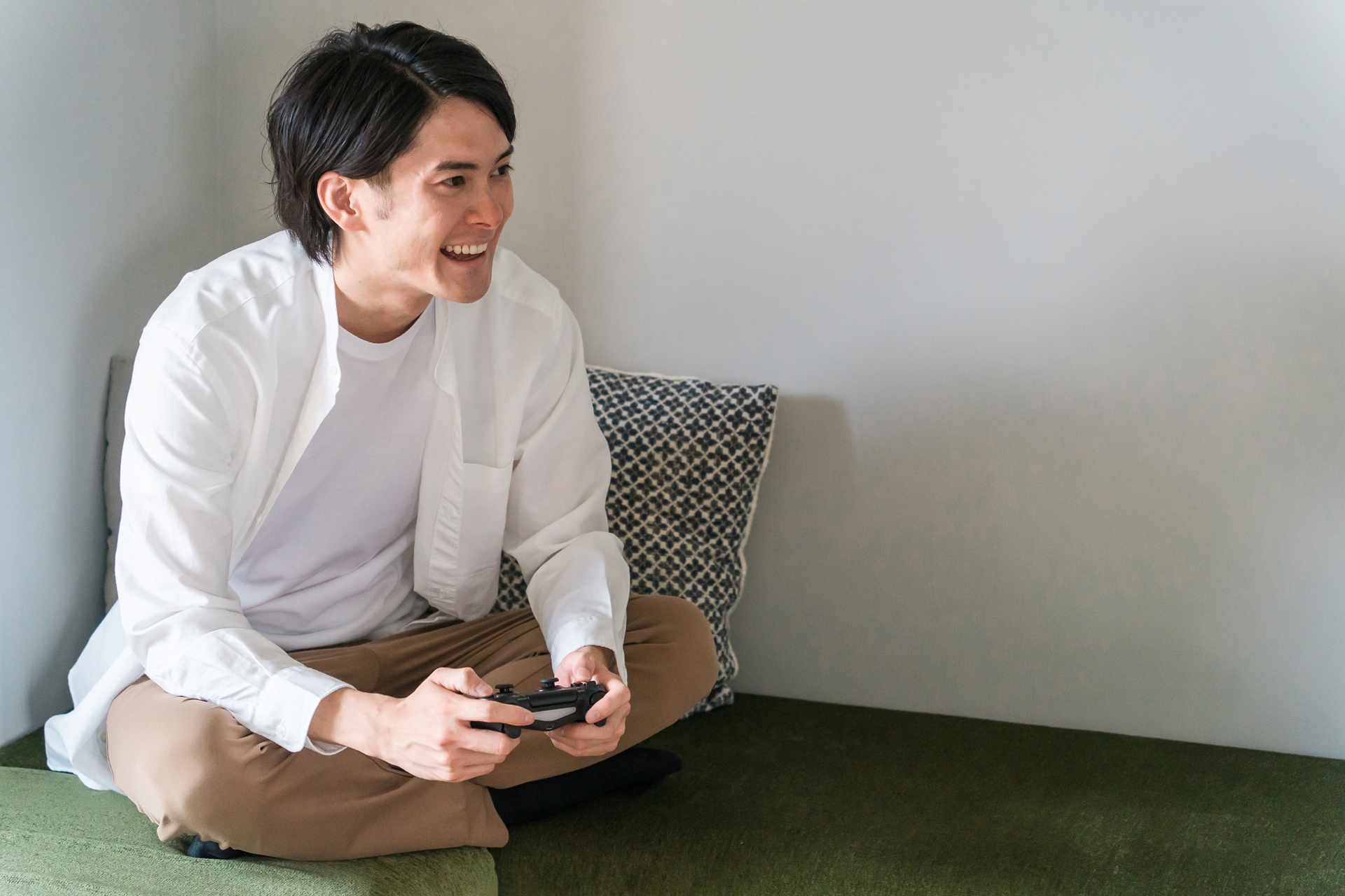 休日に家でオンラインゲームする男性