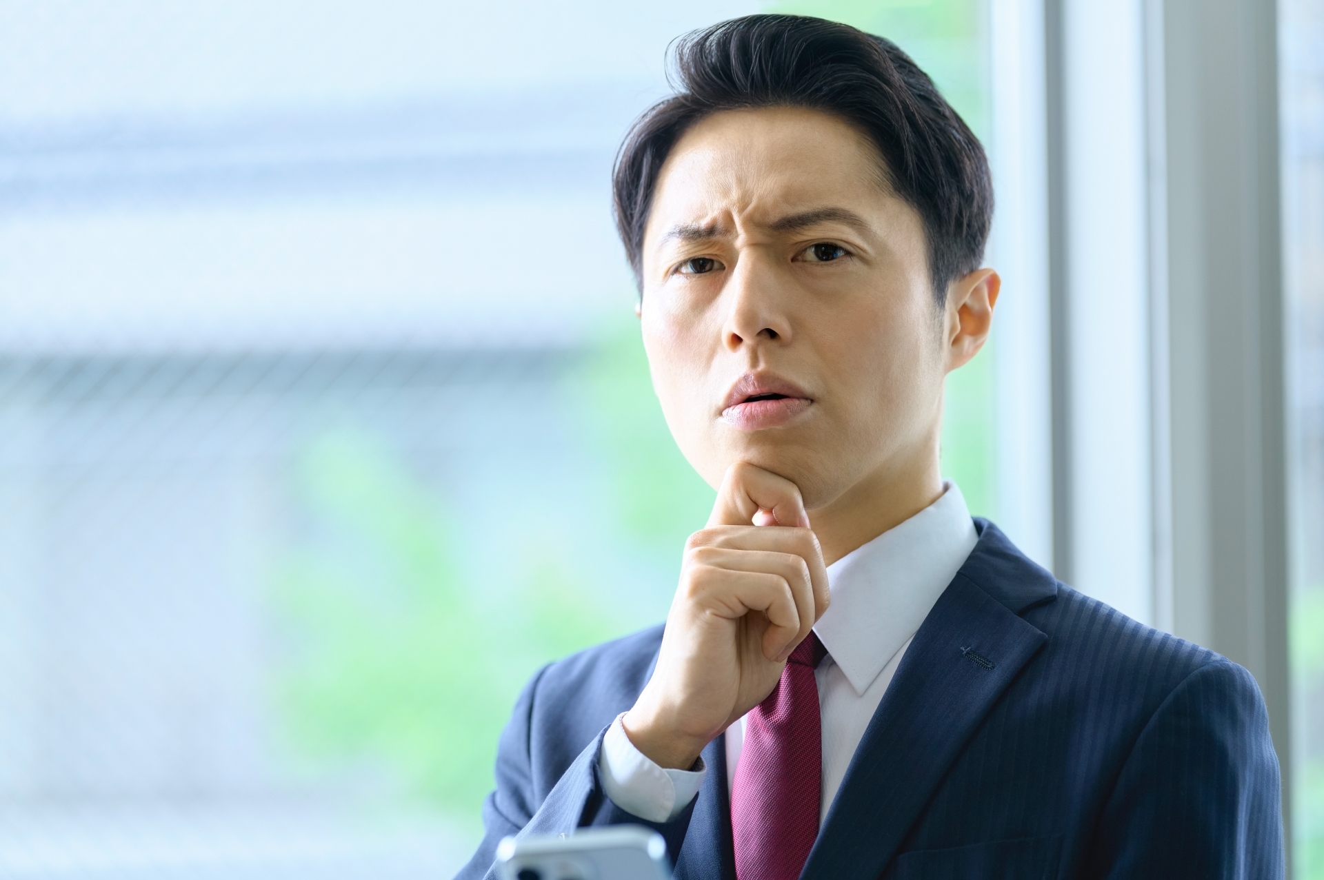 考えるビジネスマン 顔に手