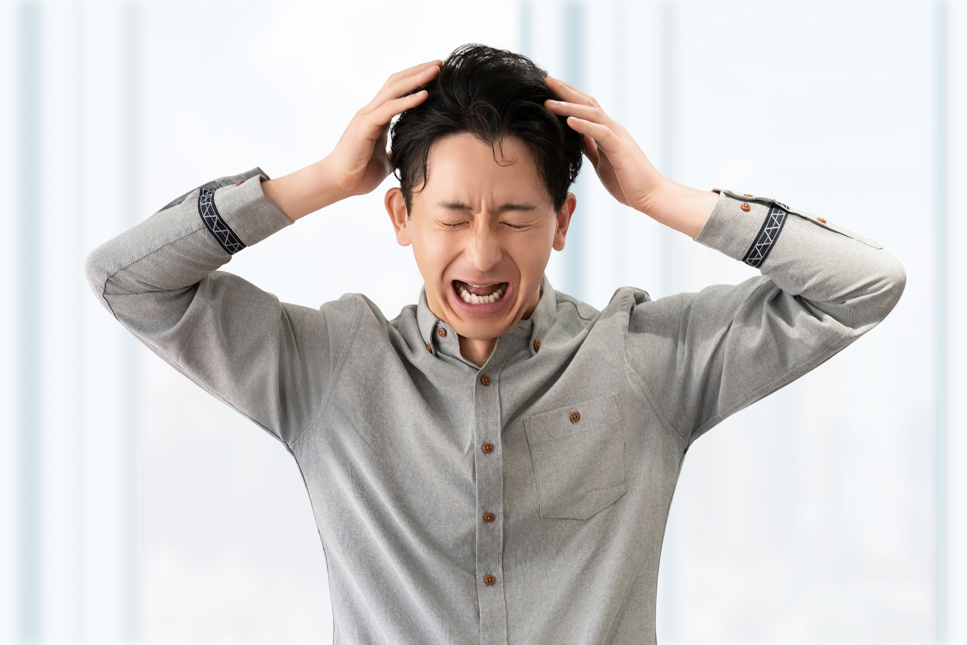 頭を抱えて悩む男性ビジネスマン
