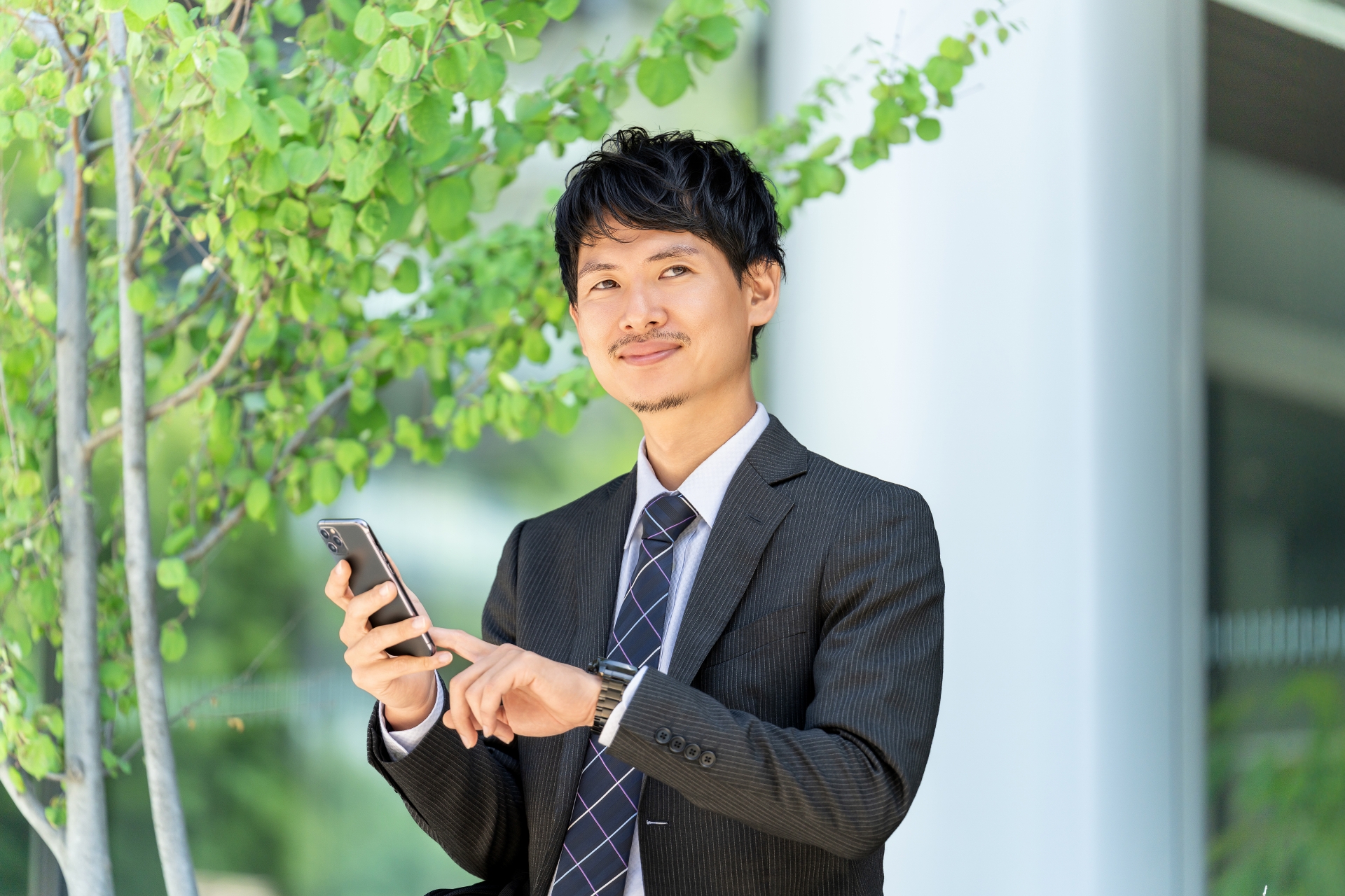 オフィス街でスマホを使う男性ビジネスマン