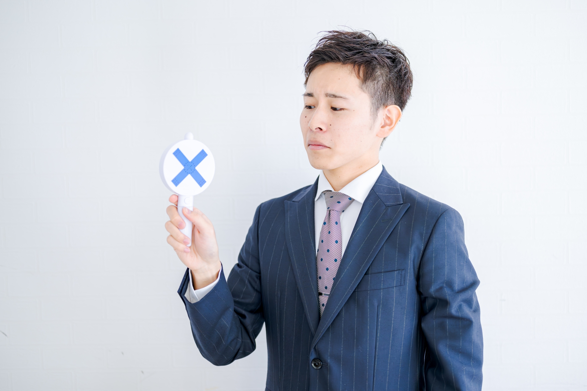 バツマークを持つ男性