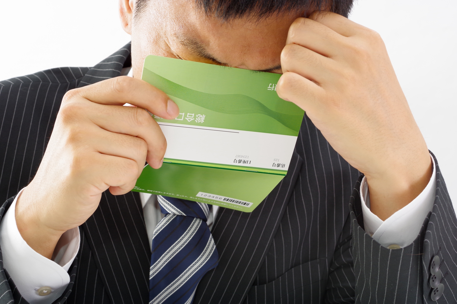 通帳で顔を覆い隠す人